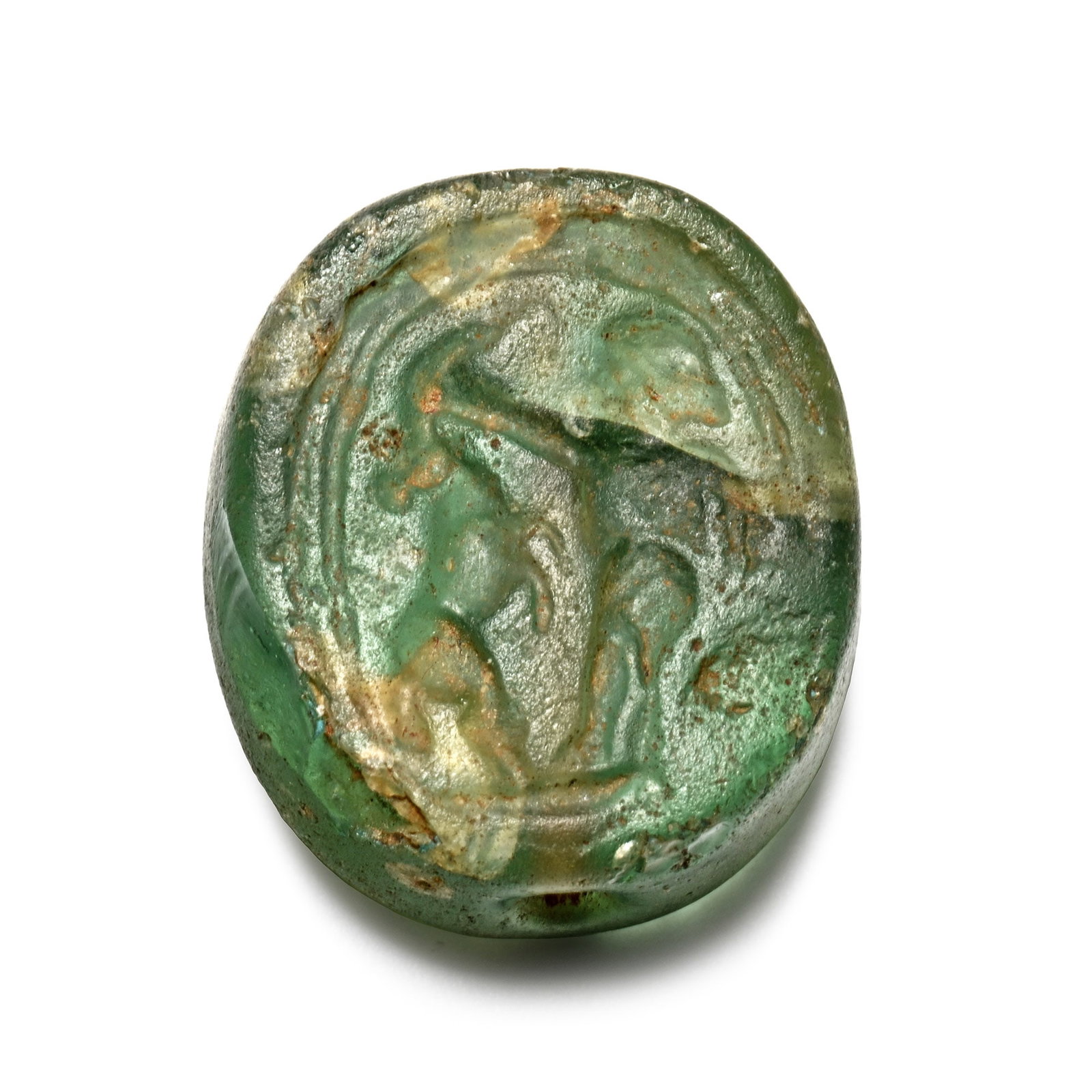 Egypto-Phoenician Glass Scarab Seal with Beast-Tamer Scene: Circa 800-600 B.C. Ellipsoid in plan with transverse piercing, impressed intaglio scene of 'beast-tamer' motif (human figure in profile with one arm extended towards a rampant ibex); aqua glass; repai