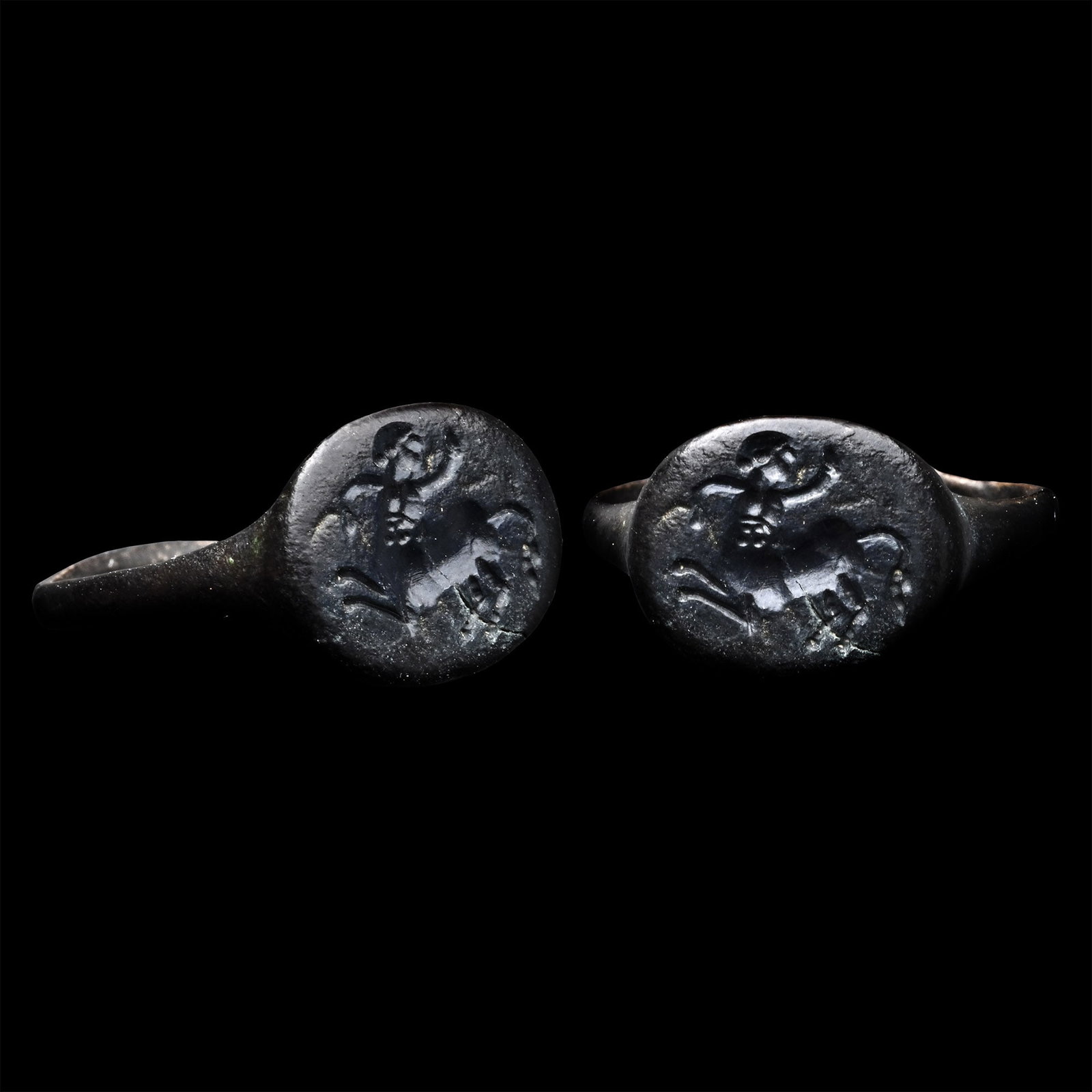 Greek Bronze Ring with Centaur: 3rd-2nd century A.D. With a slender hoop and an oval bezel with a galloping centaur facing back with his arms raised. 3.40 grams, 22.48 mm overall, 18.34 mm internal diameter (approximate size British