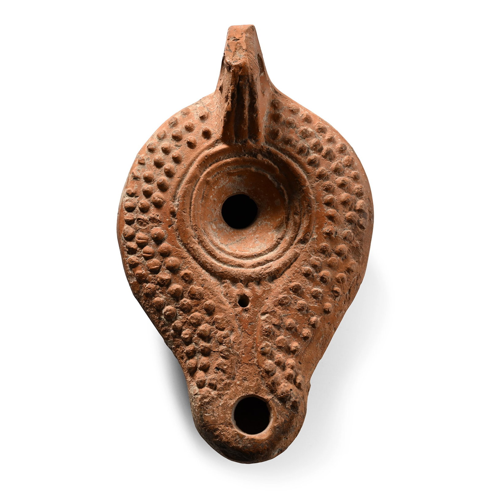 Late Roman Terracotta Oil Lamp with Stipple Decoration: 5th-6th century A.D. Comprising a rounded nozzle with a low channel and a recessed discus with a filler hole, the body decorated with three rows of raised pellets, with a loop handle to the rear and a