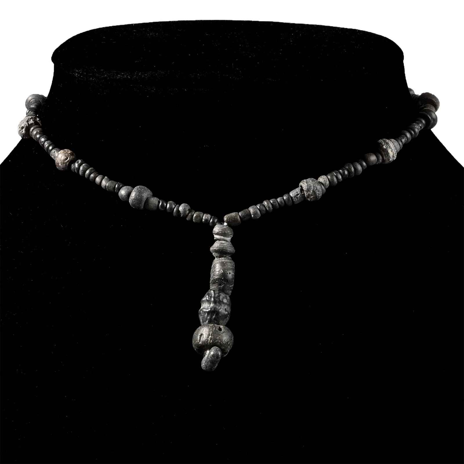 Roman Black Glass and Other Bead Necklace String: 1st-4th century A.D. and later. Composed mainly of small oblate beads interspersed with larger oblate beads, the central feature composed of four large beads; restrung. 8.7 grams, 32.2 cm (12 5/8 in.)