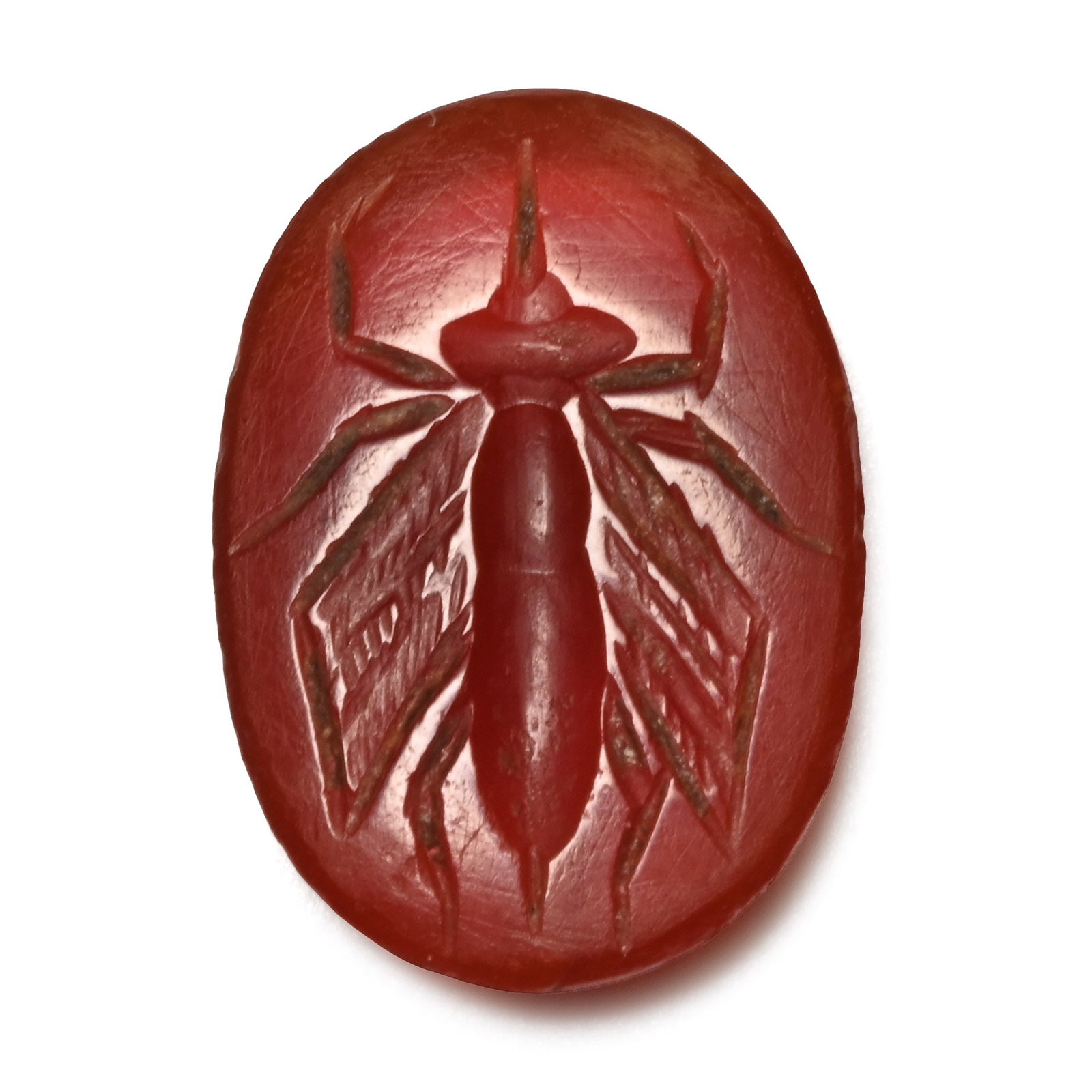 Roman Carnelian Gemstone with Insect: 2nd-3rd century A.D. Red carnelian intaglio with an incuse image of a flying insect with a stinger and a long needle extending from the head; accompanied by a museum-quality impression. 0.53 grams, 12