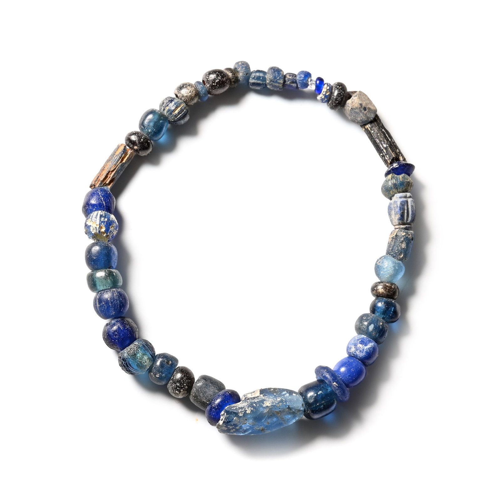 Roman Dark Blue Glass Bead Bracelet: 1st-4th century A.D. and later. Composed mainly of oblate, spherical and tubular beads, restrung with an elasticated string. 6.46 grams, 17 mm (5/8 in.). [No Reserve] Ex Ancient Art Shop, Windsor, UK,