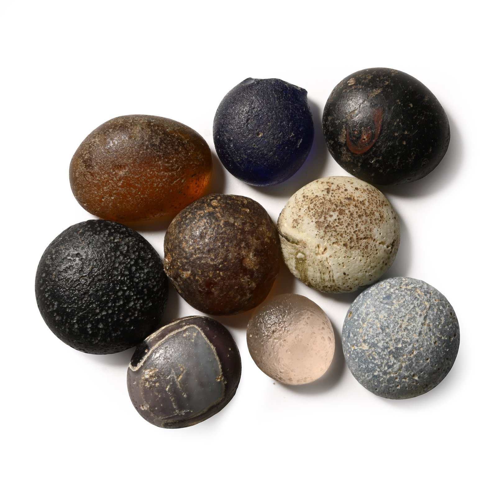 Roman Glass 'Oculi' Gaming Counter Collection: 1st-4th century A.D. Comprising nine domed counters in various colours. Cf. the find of the ?Doctor Grave? at Colchester with similar pieces in Hawkes, N., The Times, Roman board game found at burial