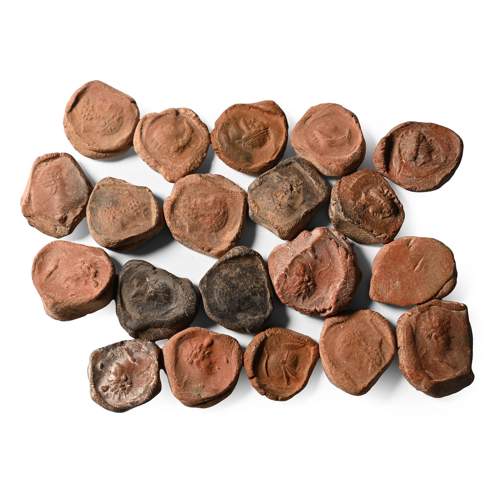 Roman Terracotta Bullae, Tesserae or Token Group: 3rd century B.C.-1st century A.D. A mixed group of ceramic bullae, tesserae or theatre tokens bearing low-relief motifs, mainly consisting of profile busts of deities. 41.2 grams total, 17-22 mm (5/8 