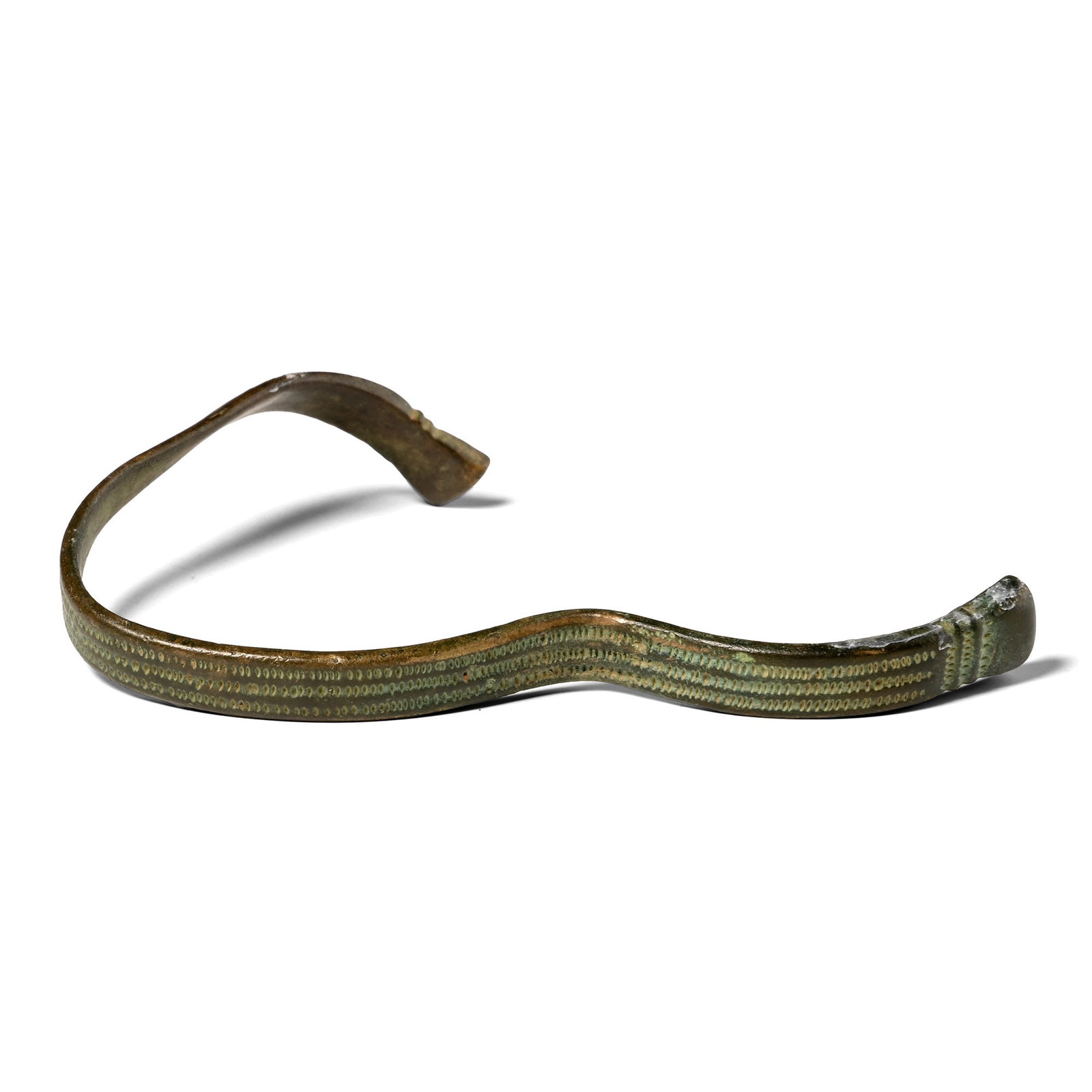 Romano-British Bronze Decorated Bracelet: England, 1st century A.D. A complete penannular armlet or wide-cuff bracelet formed from a rectangular-section strip; decoration on the external surface consisting of three contiguous rows of punched 