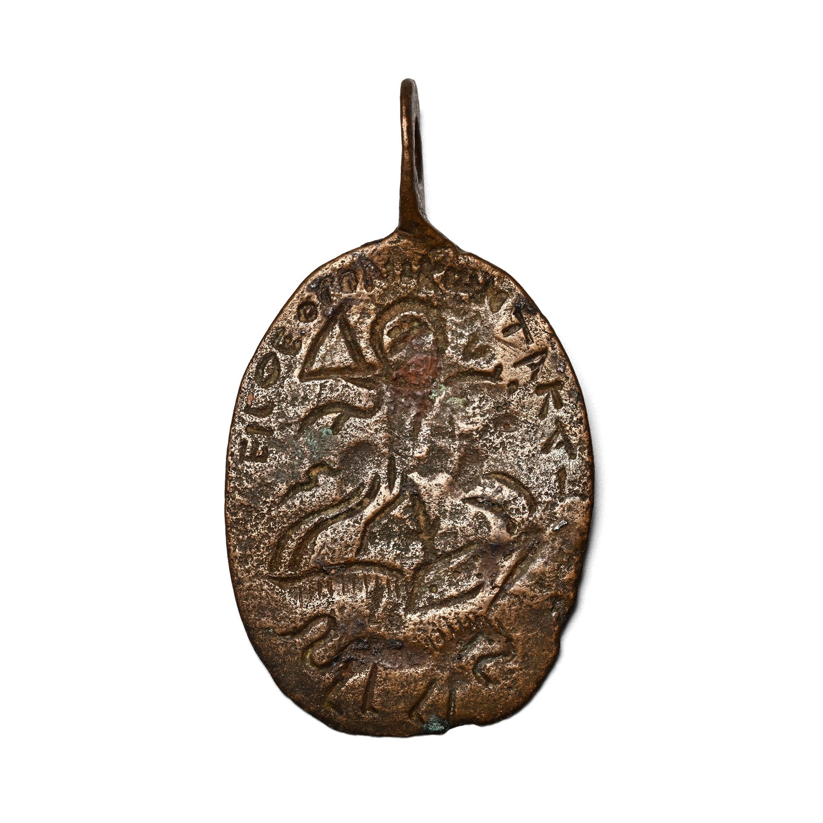Eastern Roman Bronze Amulet with Saint Spearing the Dragon: Circa 14th century A.D. Oval pendant with integral suspension loop, one side with armoured Saint Theodore or Saint George on horseback slaying the dragon with a barbed spear, a lion beneath and a Gree