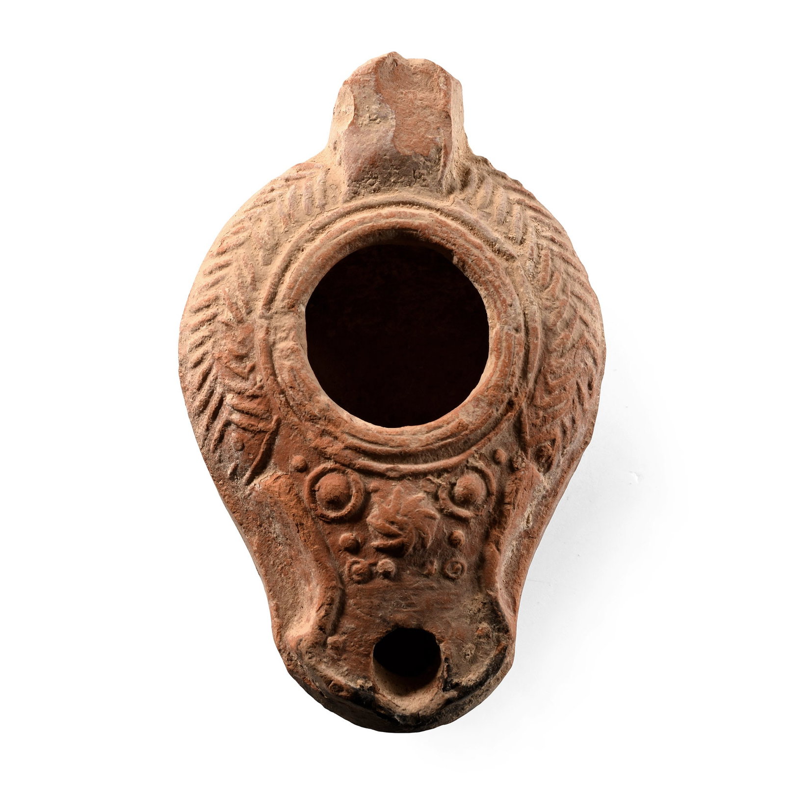 Byzantine Terracotta Slipper Oil Lamp with Chevrons: Holy Land, circa 5th-8th century A.D. Lug handle to the rear, band of herringbone pattern around the filler hole, the nozzle with a sunburst motif flanked by ring-and-dot motifs; low basal ring with a