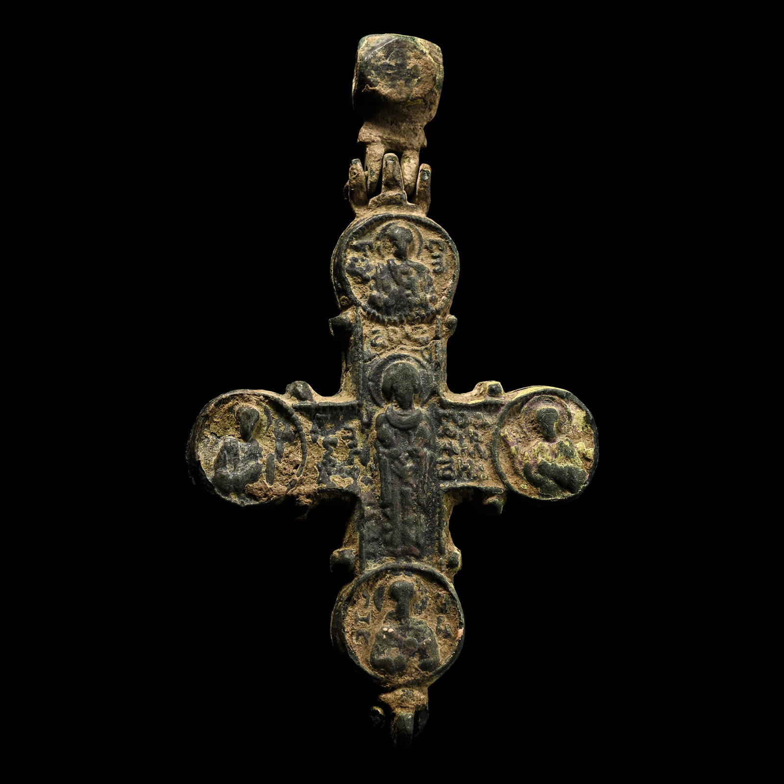 Large Byzantine Bronze Reliquary Cross Pendant with Christ and Saints: Circa 10th-12th century A.D. Bifacial enkolpion with roundel to end of each arm, hinged polyhedral suspension loop above; obverse with low-relief central Corpus Christi and bust of a saint in each rou