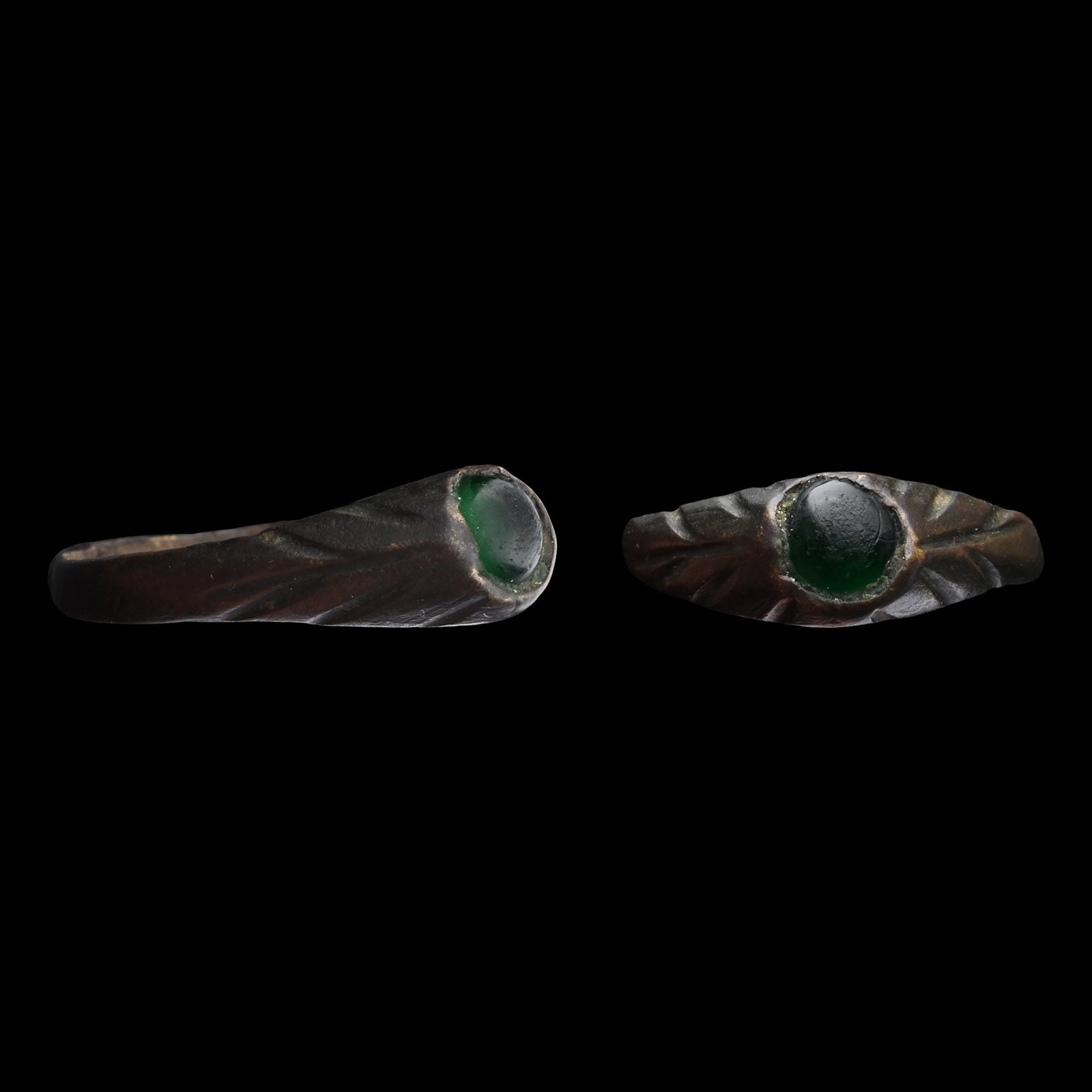 Byzantine Bronze Stirrup Ring with Green Gem: Circa 14th-15th century A.D. With a slender hoop and thickened underside, conical bezel set with incuse foliage detailing, inset cabochon. 2.96 grams, 23.50 mm overall, 16.02 x 15.43 mm internal diame
