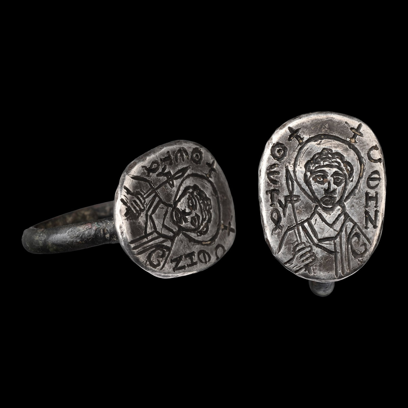 Post Byzantine Silver Ring with Saint Demetrios: 18th-19th century A.D. With a D-section hoop and a large oval bezel with a nimbate bust holding a staff, Greek inscription '?ET?' and 'C?HN' flanking the bust. 6.99 grams, 22.95 mm overall, 18.99 x 17