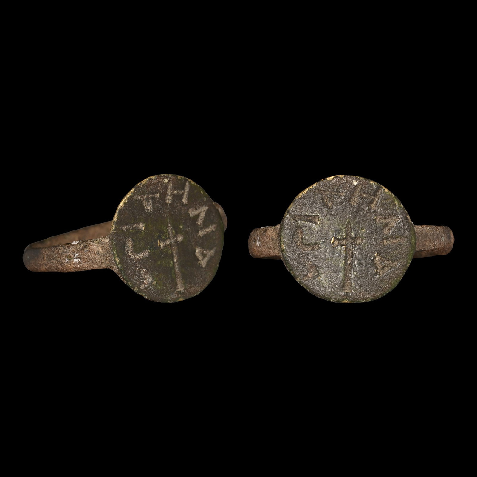 Byzantine Bronze Ring with Cross and Inscription: 6th-8th century A.D. Comprising a faceted hoop and disc bezel with incised cross and legend '?I [.]HNA'. 2.26 grams, 22.83 mm overall, 19.49 x 17.19 mm internal diameter (approximate size British P, U