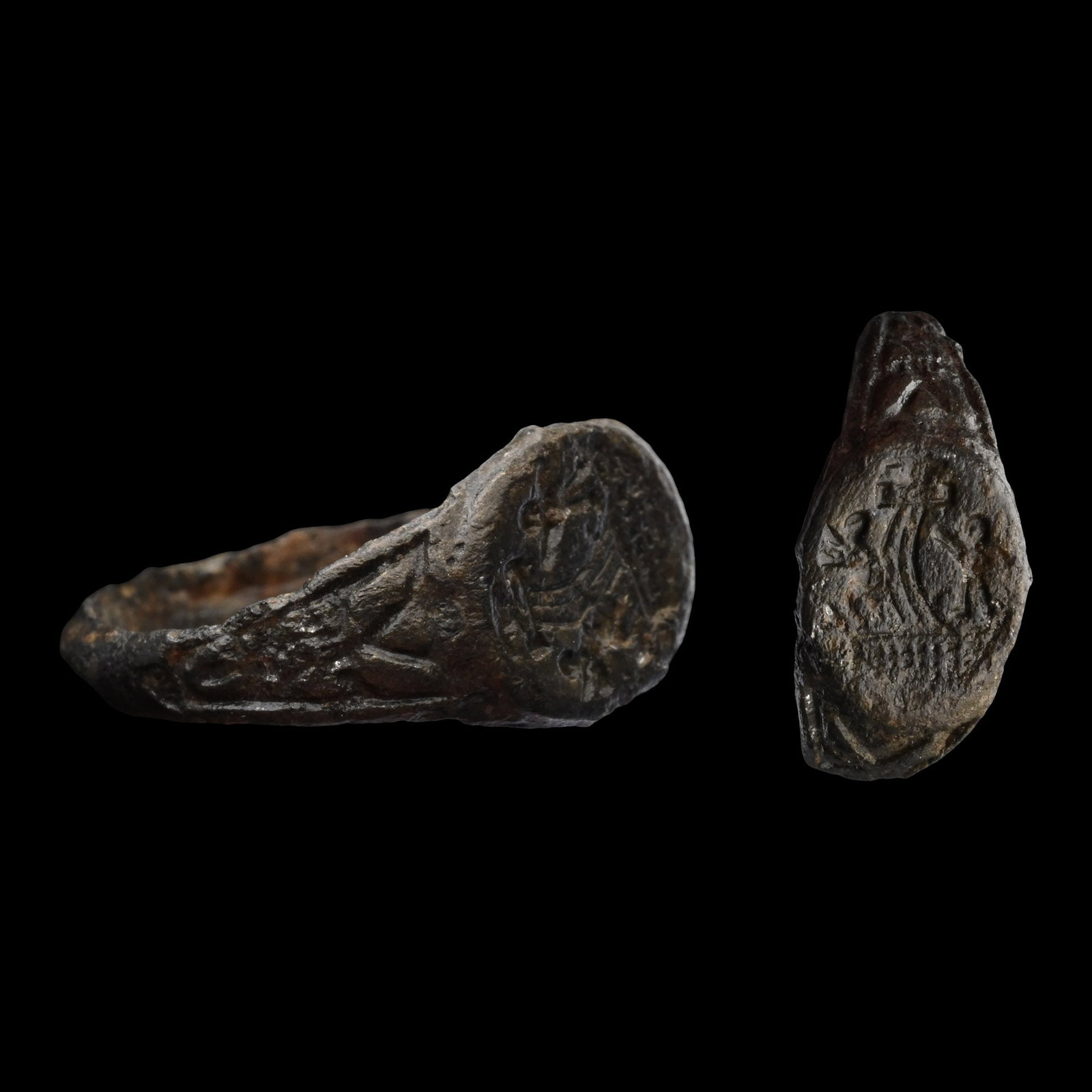 Byzantine Bronze Ring with Stavrosis and Two Roman Soldiers: 10th-11th century A.D. Comprising a D-section hoop and an oval bezel with a cross flanked by two adoring figures. 1.66 grams, 17.78 mm overall, 15.34 mm internal diameter (approximate size British I, 