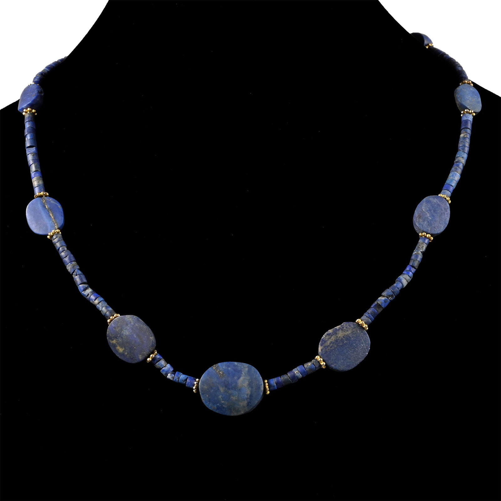Bactrian Style Lapis Lazuli Bead Necklace String: 20th century A.D. Composed of coin-shaped and tubular beads interspersed with metal spacers, restrung. 33.8 grams, 49 cm (19 1/4 in.). [No Reserve] Acquired in the 1990s-early 2000s. Ex London, UK, co