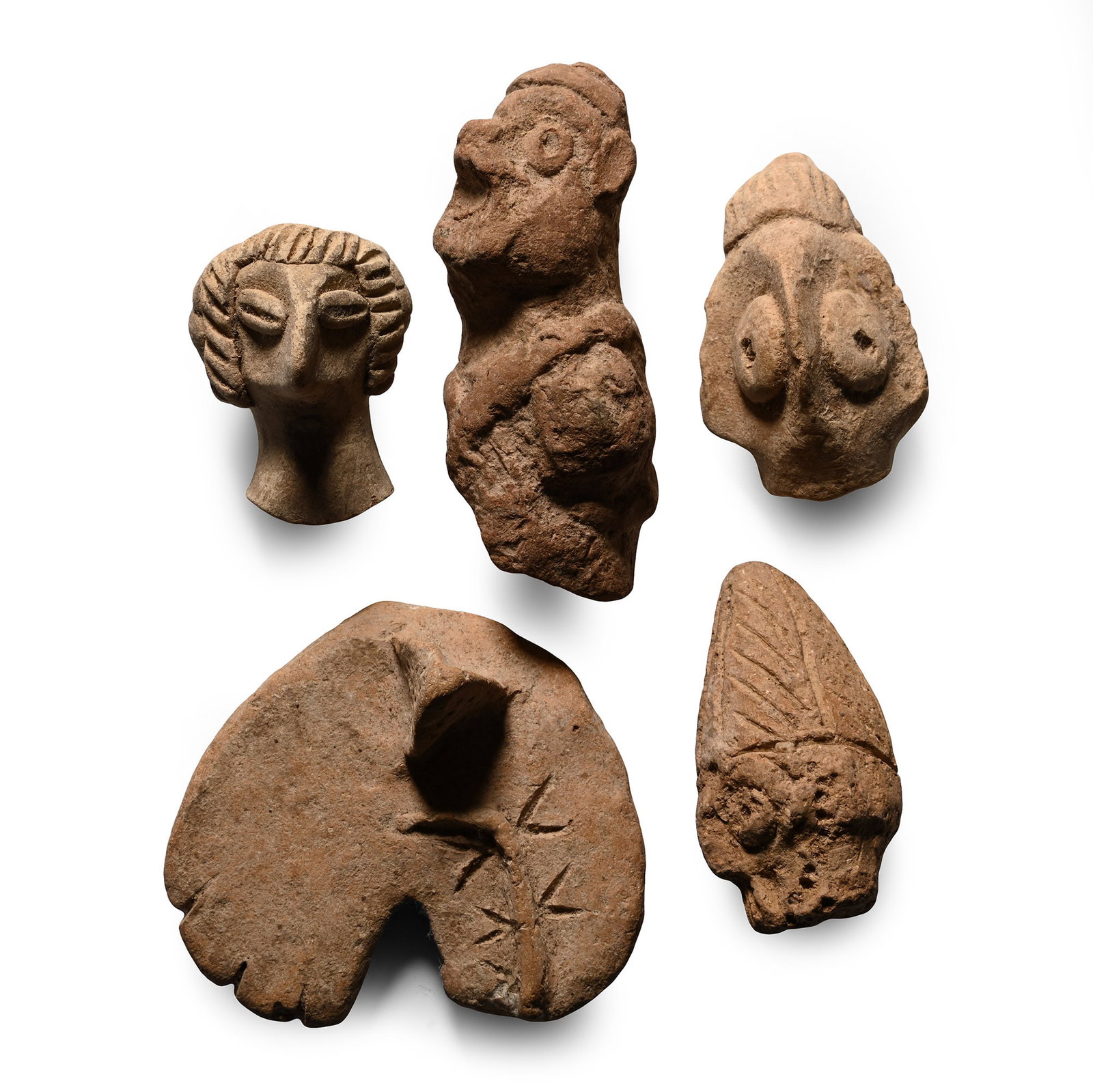 Western Asiatic Terracotta Idol Head and Other Fragment Collection: 3rd-1st millennium B.C. Comprising four heads with applied and impressed details, and a crescentic disc with raised decoration. Cf. Various, Idoles, Au commencement ?tait l?image, ? la Reine Margot, 2
