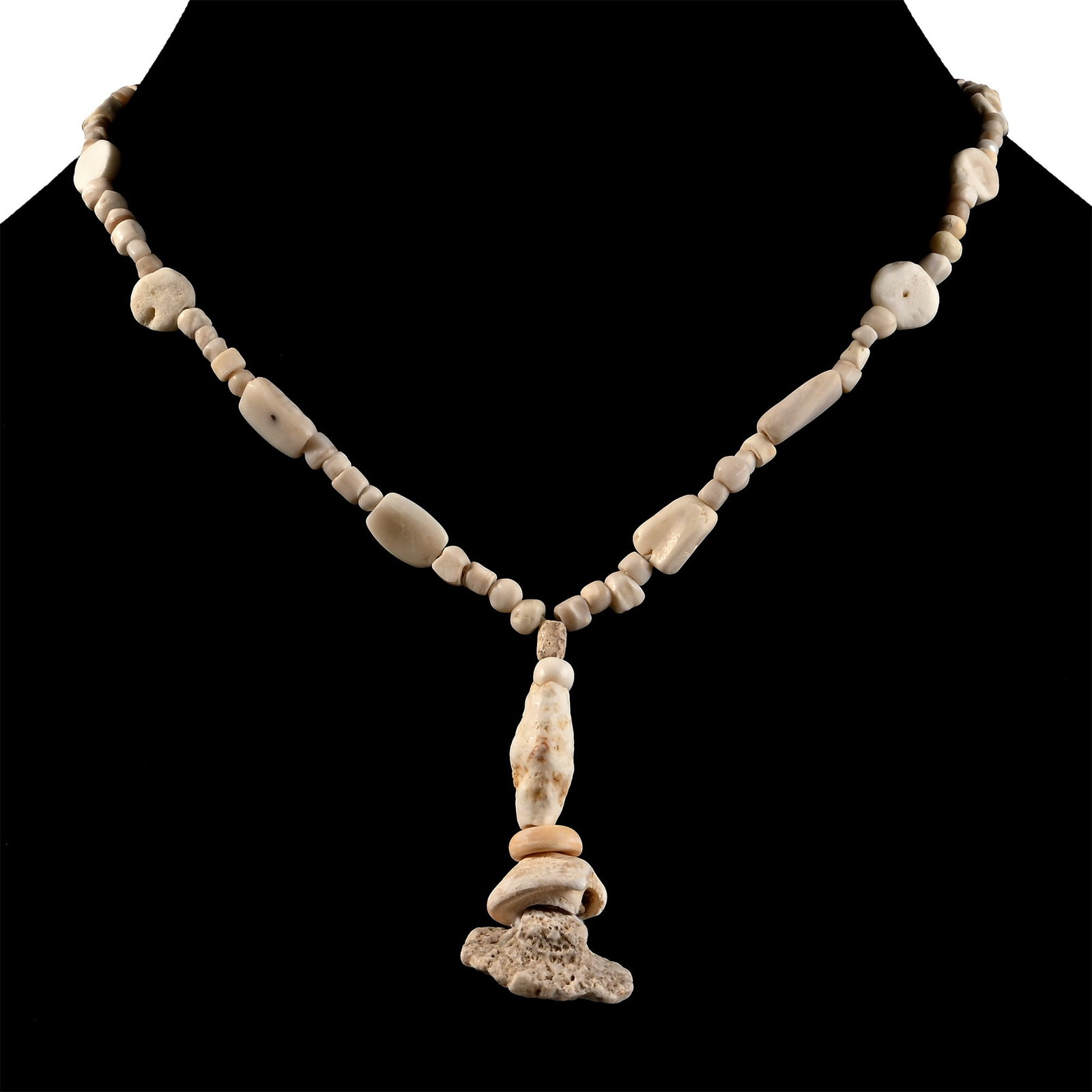 Western Asiatic Cream Glass and Other Bead Necklace String: 1st millennium B.C. and later. Composed of small oblate and other beads interspersed with larger discoid and rectangular beads, the central feature composed of larger beads, restrung. 18 grams, 29 cm 