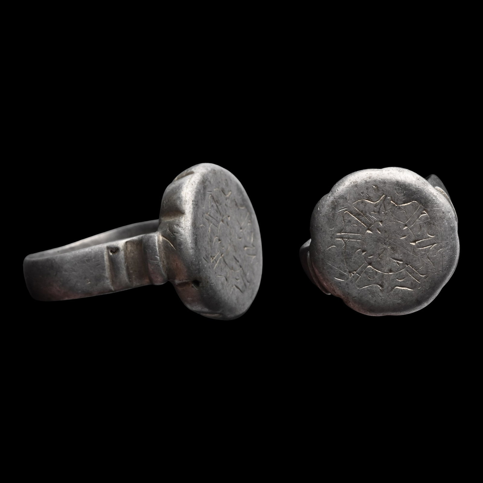 Large Western Asiatic Silver Ring with Floral Design: Circa 18th-19th century A.D. Comprising a wide hoop with curving supports projecting from the shoulders, a thick flower-shaped bezel with an engraved and gilt flower motif. 21.95 grams, 31.96 mm overa