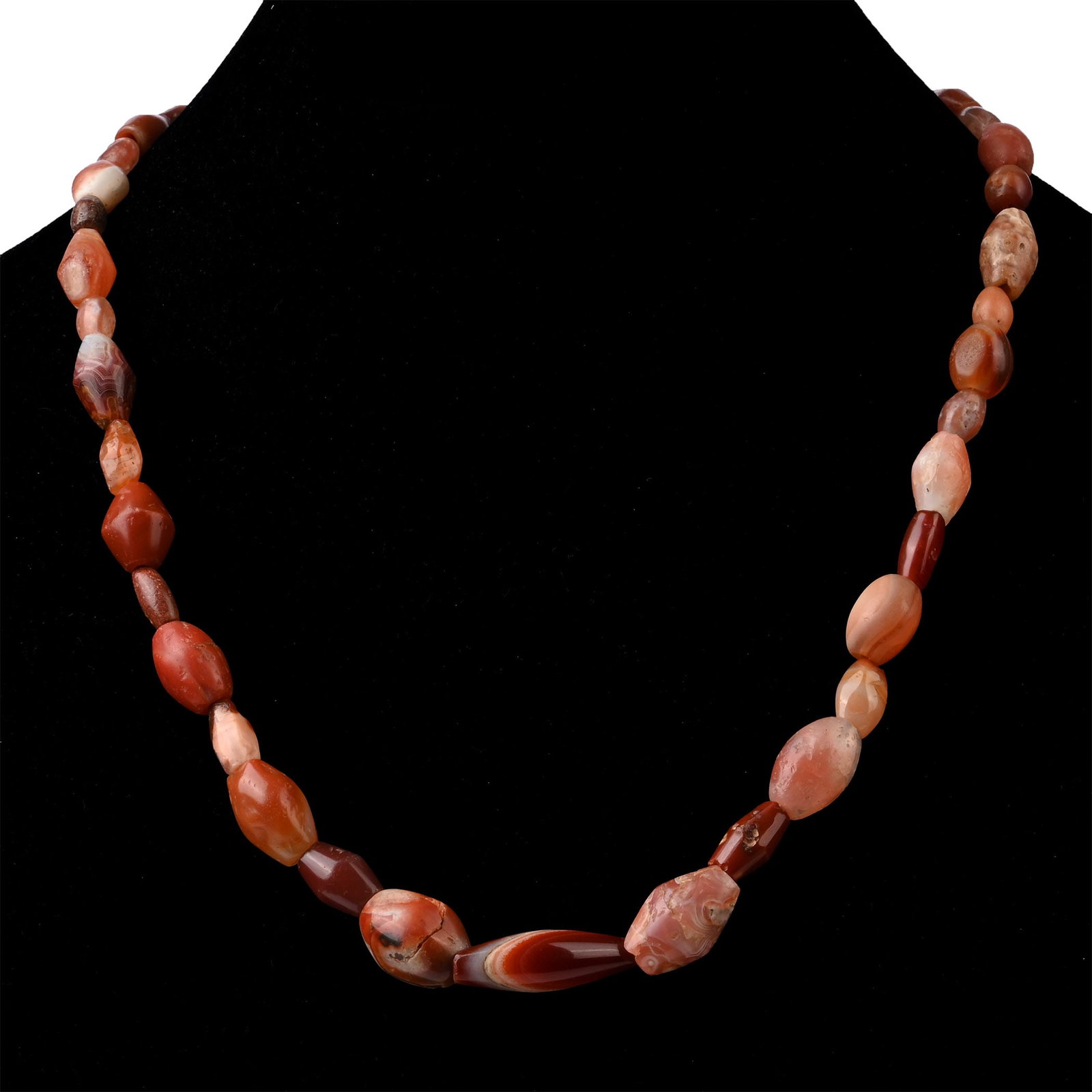 Western Asiatic Carnelian Bead Necklace: Circa 1st millennium B.C. Composed of large biconical and oval carnelian and agate beads, restrung with a modern clasp. 70 grams, 53 cm (20 7/8 in.). Ex London, UK, collection, 1990s. Accompanied by a