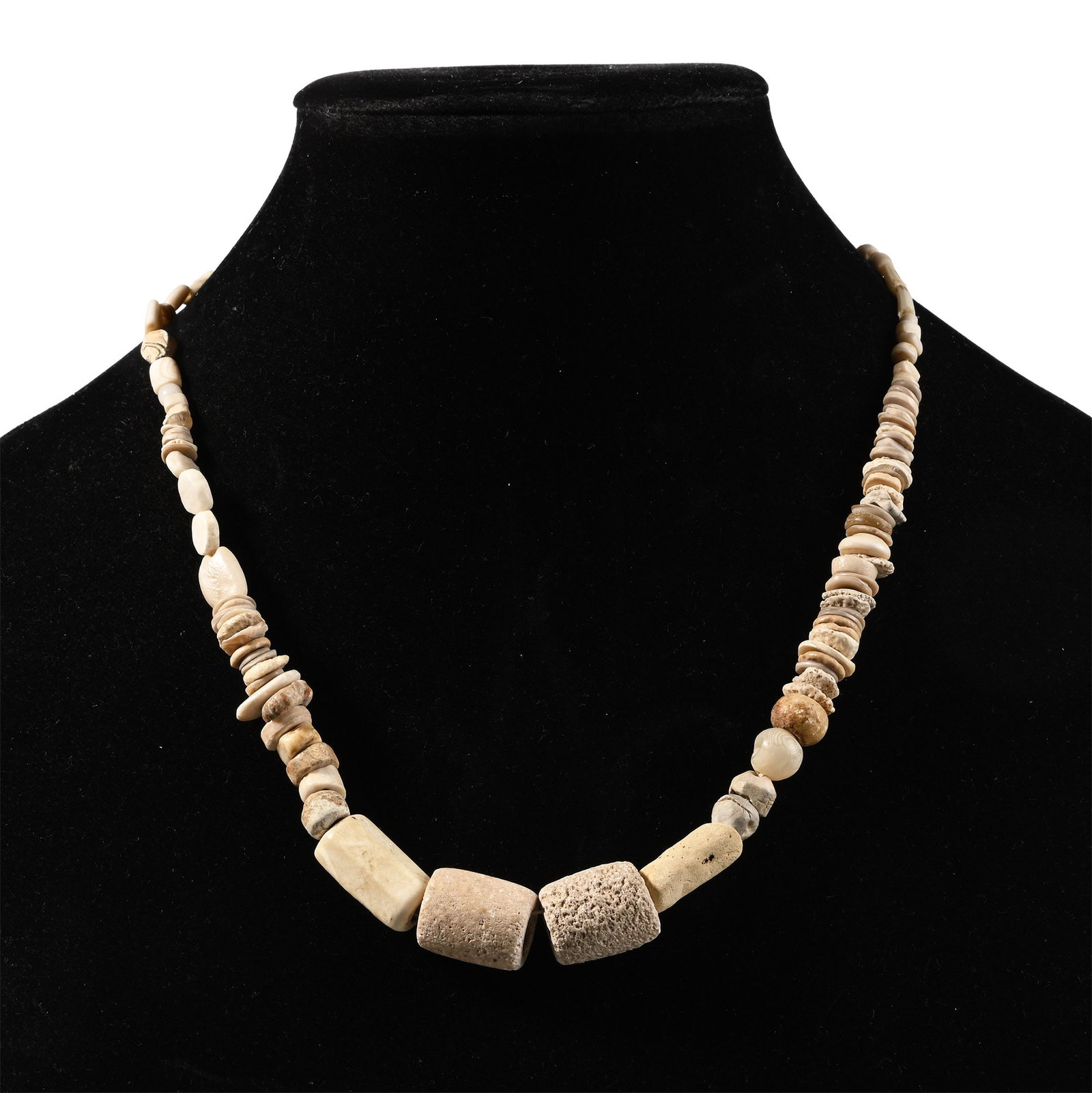 Western Asiatic Glass and Other Bead Necklace String: 1st millennium B.C. and later. Graduated group of glass, stone and shell beads with four larger feature beads at the centre; restrung. 47.1 grams, 45.5 cm (17 7/8 in.). [No Reserve] Acquired in the 19
