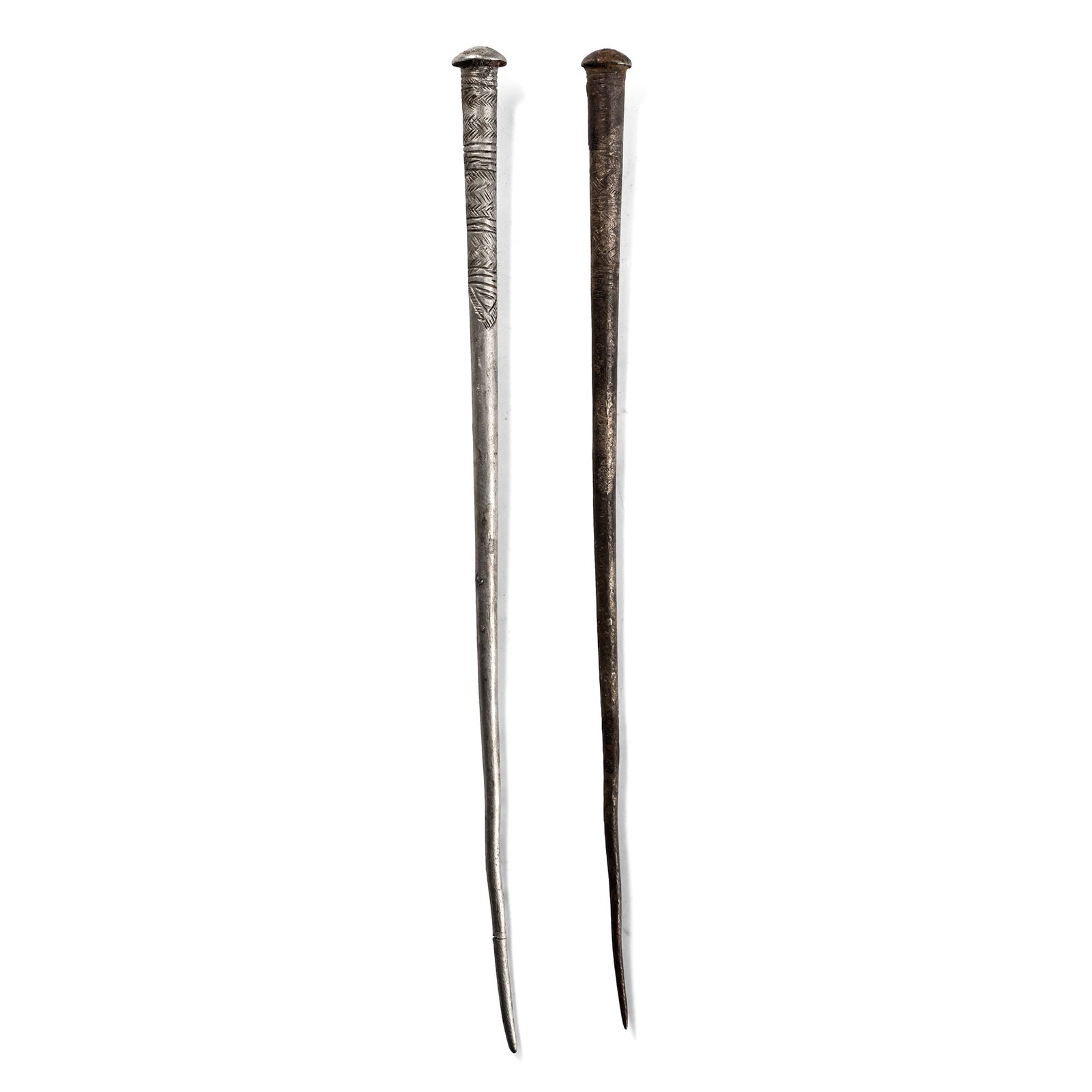 Proto-Elamite Silver Engraved Cloak Pin Pair: 2nd millennium B.C. Each with a tapering body and a domed finial, engraved bands of hatching and linear motifs. 42.4 grams total, 16.8-17.2 cm (6 5/8 - 6 3/4 in.). [2] From a UK collection formed in t