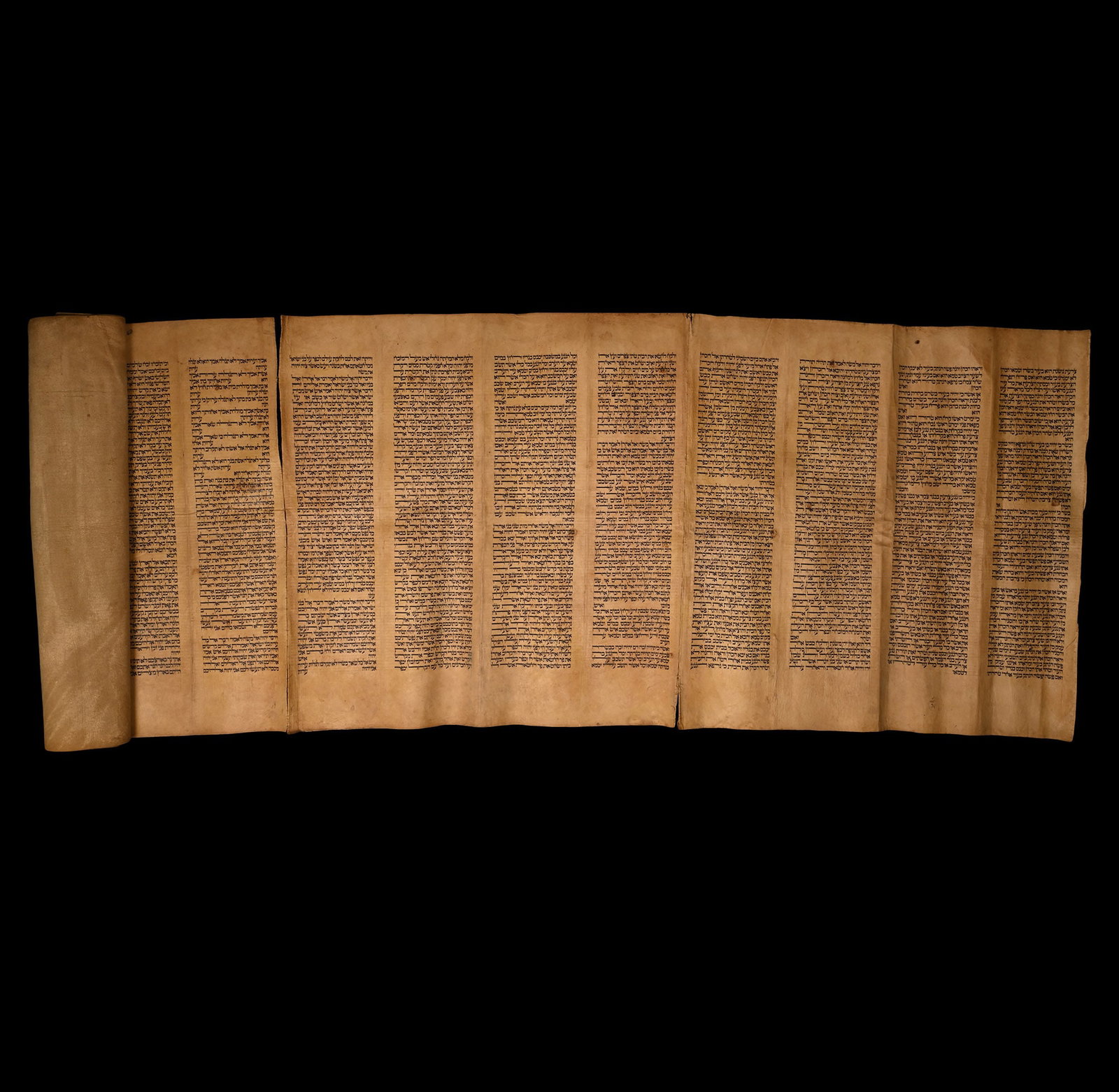 Large Hebrew Leather Scroll: 20th century A.D. A rectangular suede leather manuscript made up from panels sewn along one edge into a long rectangle; sixteen blocks of regular Hebrew script, part of a Torah scroll, including the b