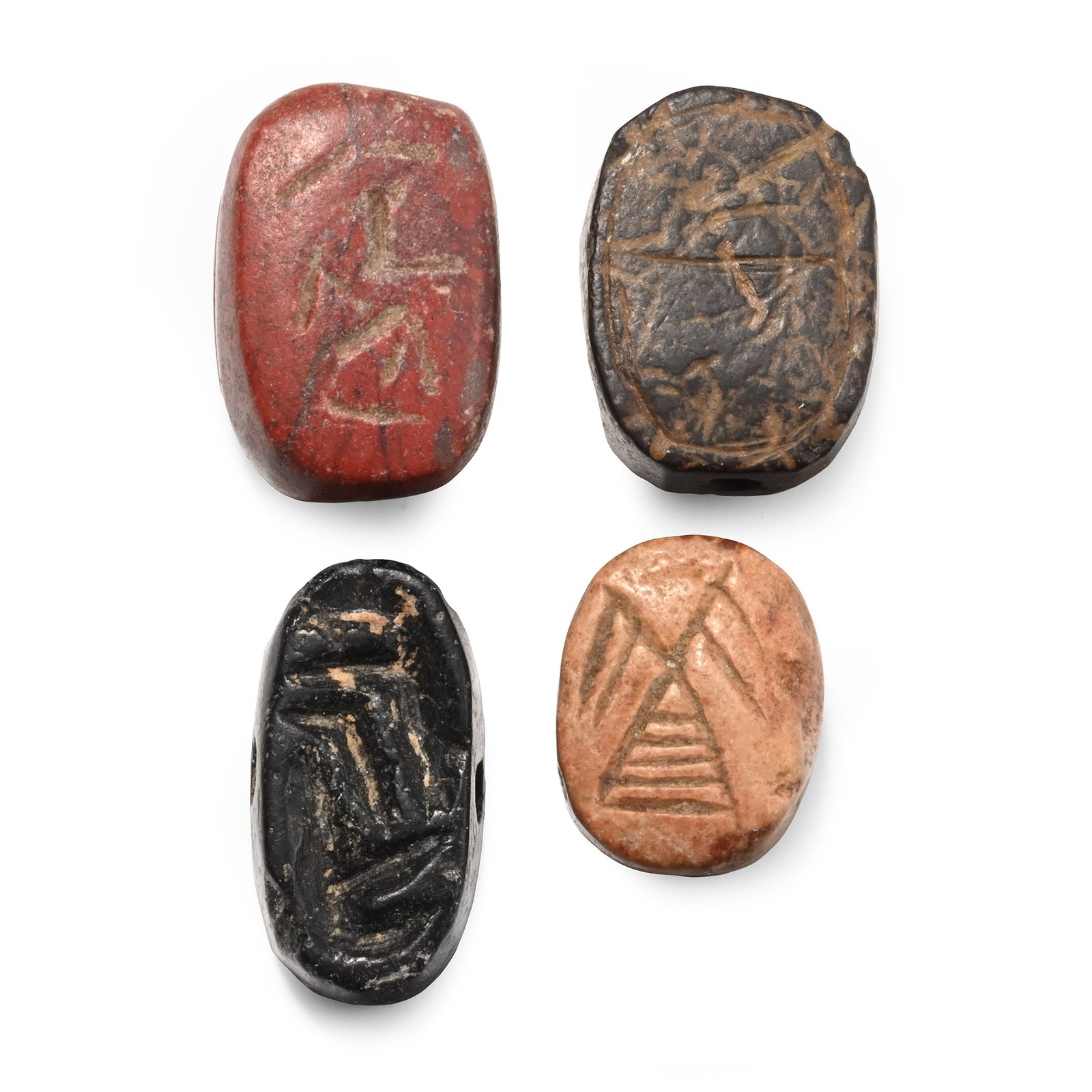Western Asiatic Stone Scaraboid Seal Group: 1st millennium B.C. Comprising three with engraved motifs on the underside, the fourth with scratched lines within a border. 13.9 grams total, 15-20 mm (5/8 - 3/4 in.). [4, No Reserve] From the privat