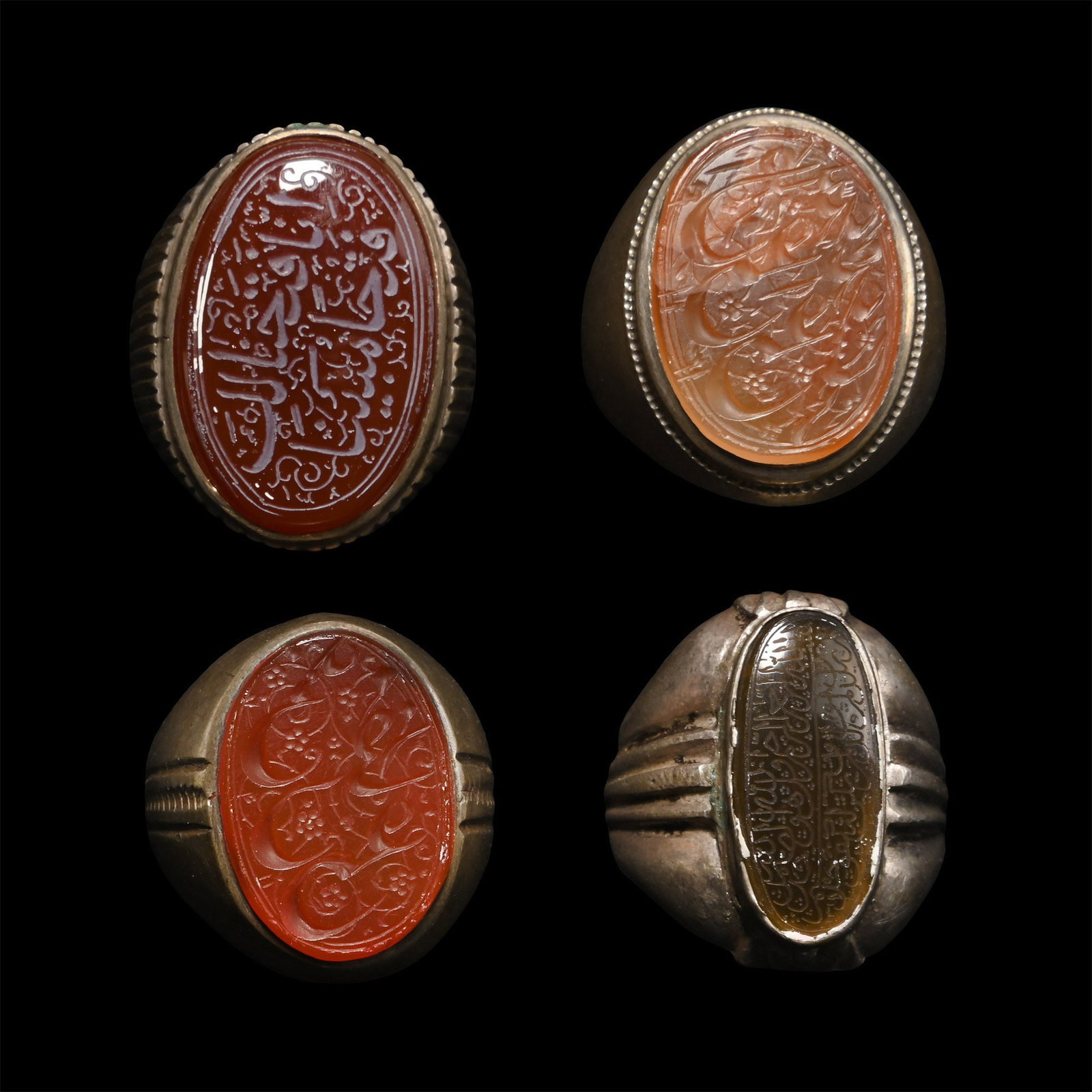 Western Asiatic Silver-Coloured Metal Rings with Calligraphic Gemstones: 20th century A.D. Comprising four rings set with carnelian gemstones, each with a densely arranged calligraphic inscription. 38.8 grams total, 25-27 mm (1 in.). [4, No Reserve] Acquired in the late 19