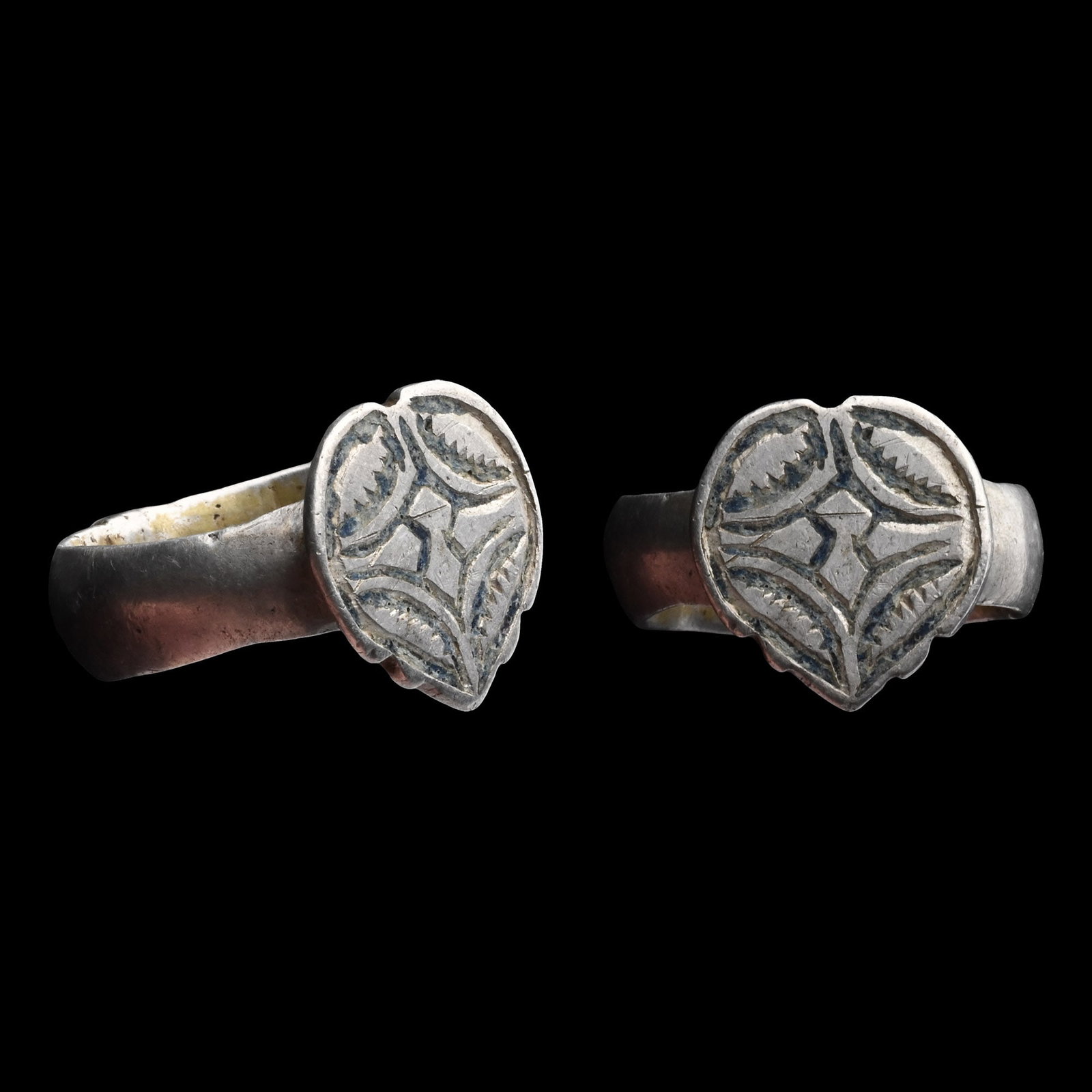 Western Asiatic Silver Ring with Heart-Shaped Bezel: Circa 17th-18th century A.D. Keeled hoop with a raised boss at the base, raised heart-shaped bezel with nielloed decoration. 10.59 grams, 23.95 mm overall, 19.62 x 18.08 mm internal diameter (approxim