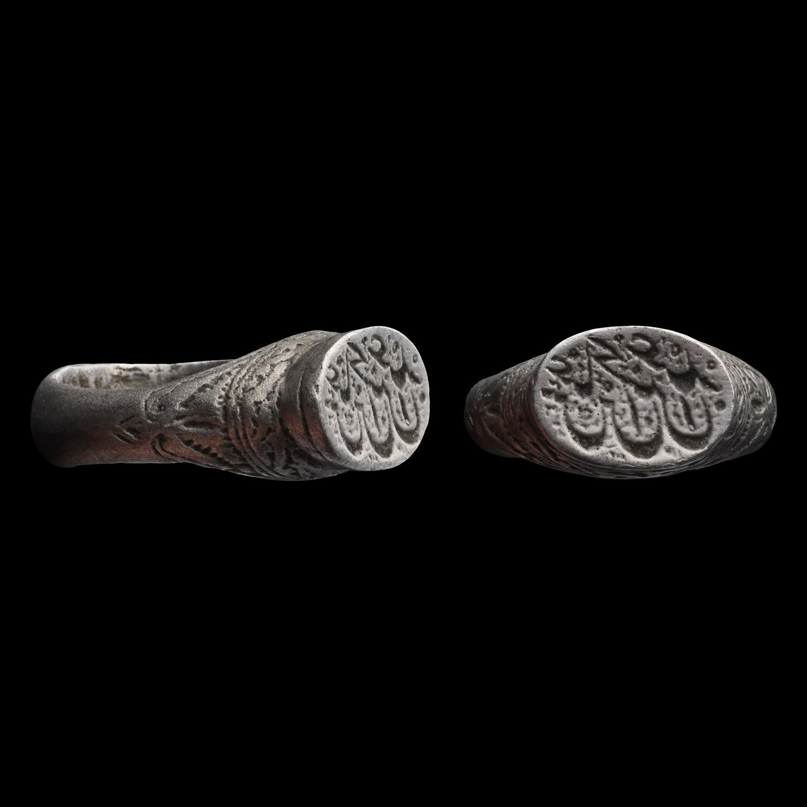 Ottoman Silver Ring with Calligraphic Inscription: Circa 17th-18th century A.D. D-section hoop with a raised boss at the base, foliate decoration on the shoulders, and a tall oval bezel with a calligraphic inscription. 12.78 grams, 26.88 mm overall, 1