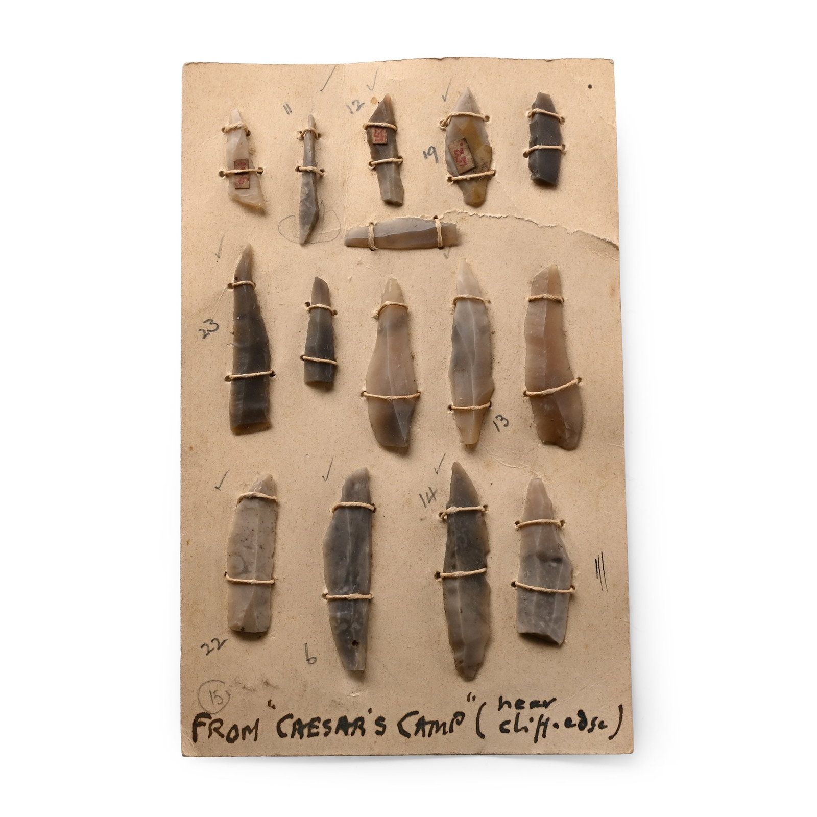 Farnham Stone Age Flint Blade Group: Neolithic Period, circa 6,000 B.P. Comprising fifteen small blades set on an old postcard with a handwritten note below 'from 'Caesar's Camp' (near cliff edge)'. 13 grams total, 14 x 9 cm including ca