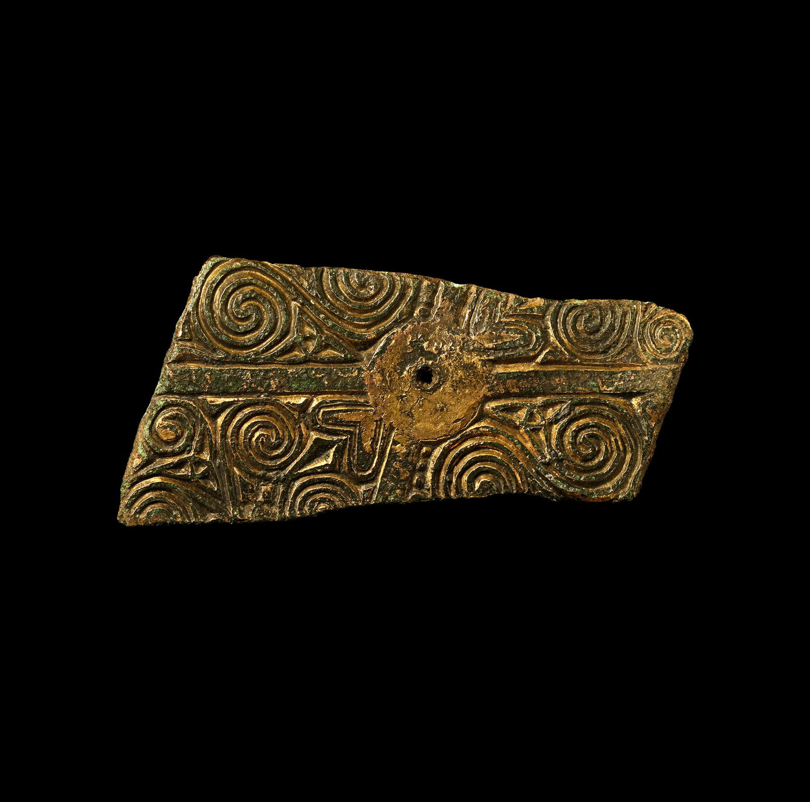Anglo-Saxon Gilt Bronze Reliquary Box Mount Fragment: Circa 6th century A.D. Irregular fragment of a bronze panel with reserved saltire and central pierced roundel; flanking panels of low-relief spirals, triquetras, scrolls and other motifs; possibly Hib