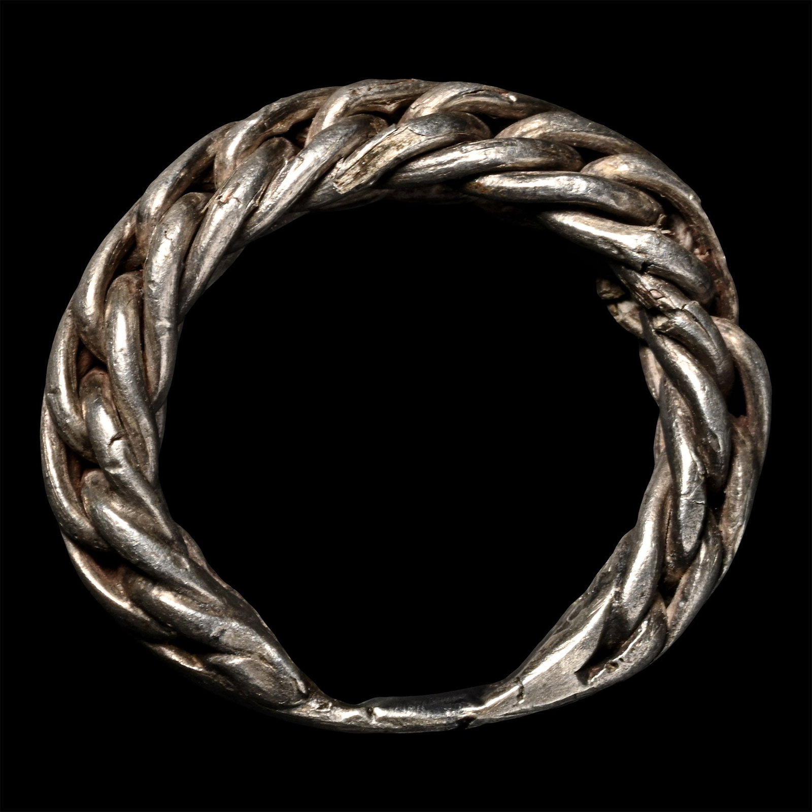 Viking Age Silver Plaited Ring: Circa 9th-11th century A.D. With triangular-section braided shank hammered at the base. 4.32 grams, 25.31 mm overall, 17.36 mm internal diameter (approximate size British L, USA 5 3/4, Europe 11.24, J