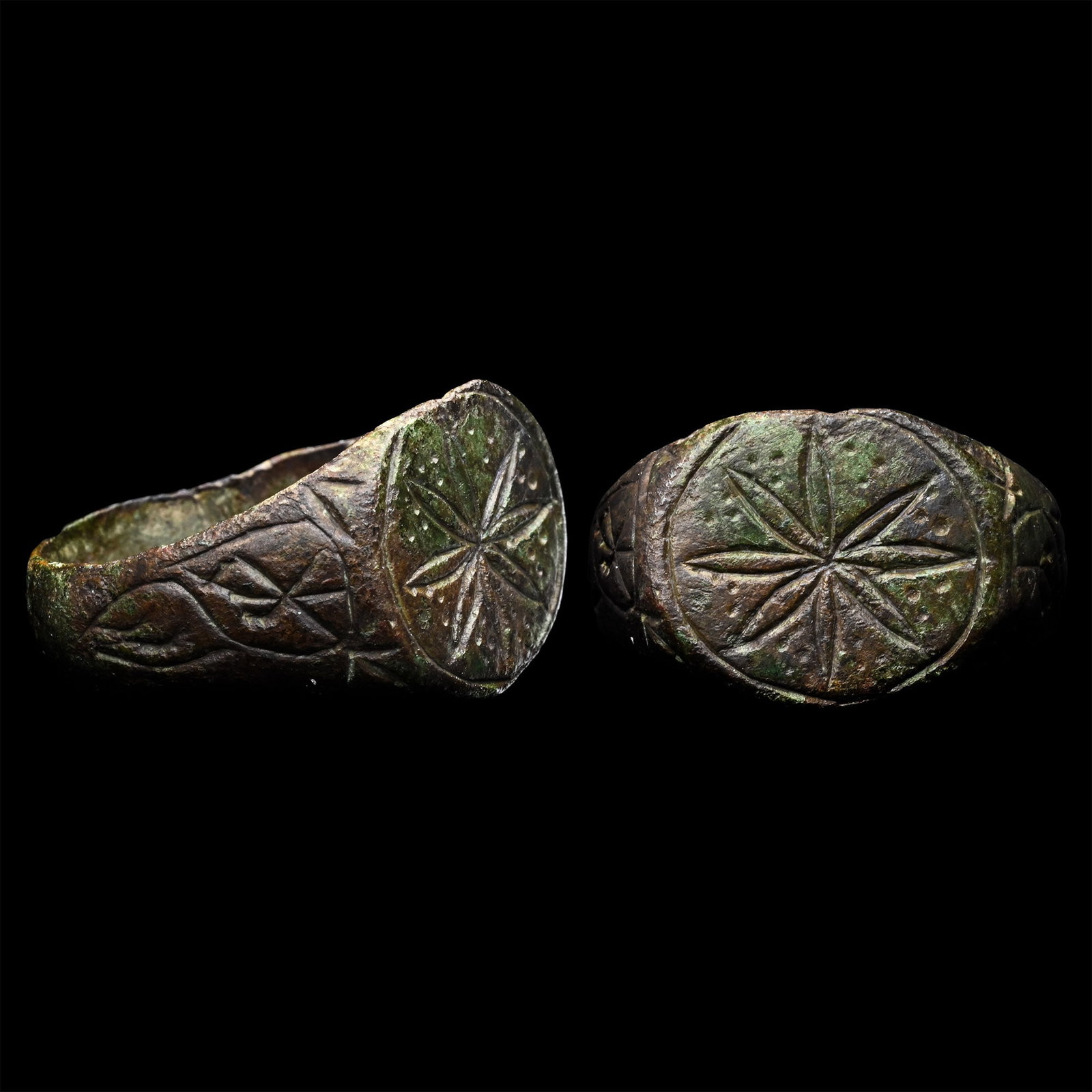 Medieval Bronze Ring with Petalled Flower: 12th-14th century A.D. With a wide hoop and an oval bezel with an eight-petalled flower on a pointill?-decorated field. 5.92 grams, 21.49 mm overall, 19.25 mm internal diameter (approximate size Briti