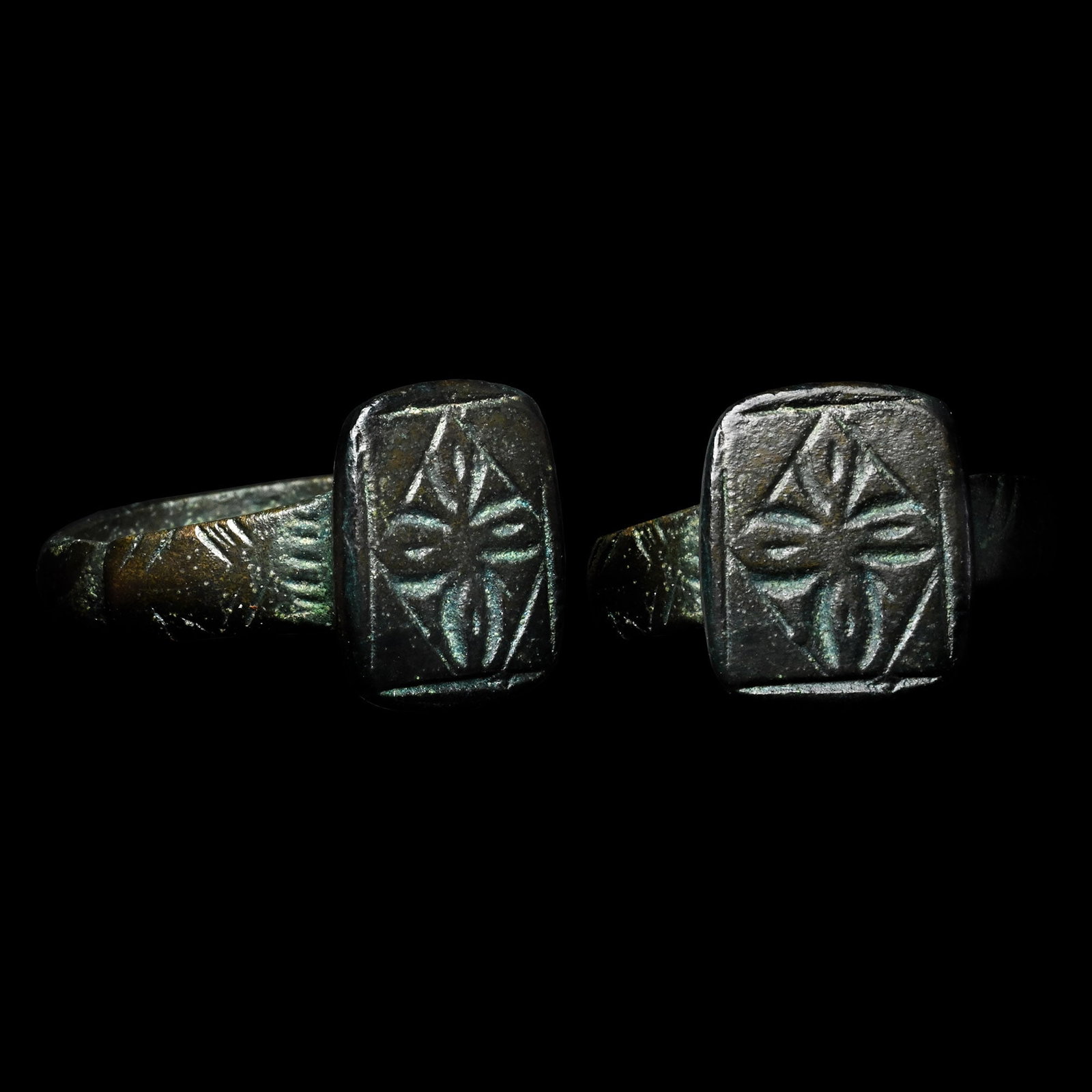 Medieval Bronze Ring with Petalled Cross in Lozenge: 15th-16th century A.D. Comprising a thick D-section hoop with stepped shoulders with hatching, a rectangular bezel with a cross motif. 5.59 grams, 24.66 mm overall, 17.51 x 19.24 mm internal diameter 