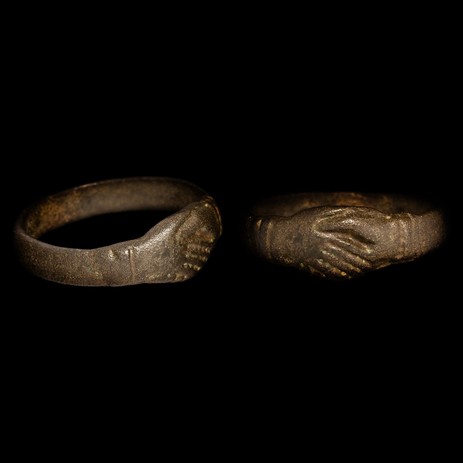 Stuart Period Clasped Hands Ring: Circa 17th century A.D. Comprising a rectangular-section hoop and the bezel formed as clasped hands with ribbed cuffs. 3.37 grams, 22.97 mm overall, 18.85 x 19.07 mm internal diameter (approximate siz