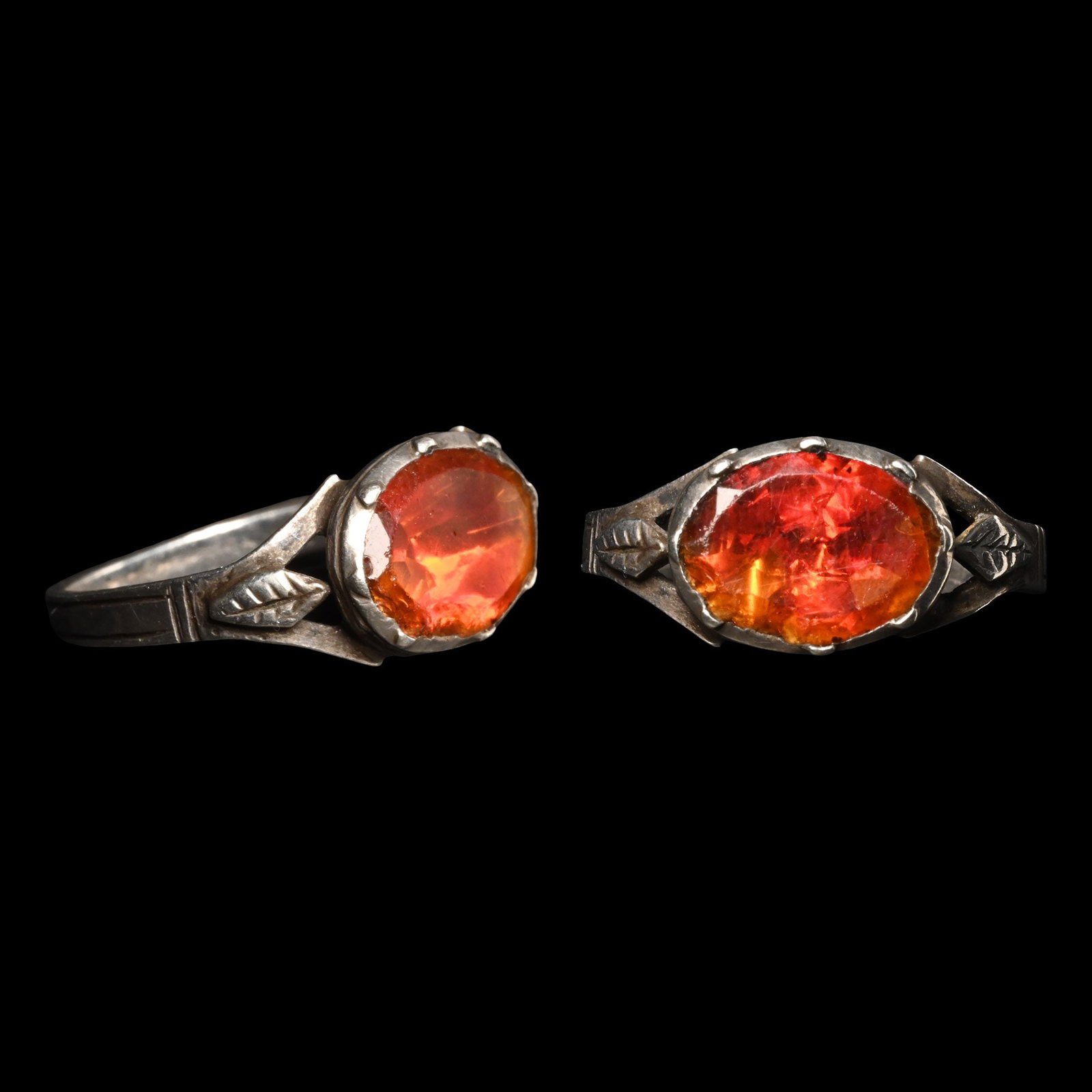 Post Medieval Silver Ring with Vibrant Blood Orange Glass Insert: France, 18th century A.D. Flat-section hoop and ellipsoid bezel with leaf detail to the shoulder, orange glass insert. 2.07 grams, 21.36 mm overall, 17.44 x 15.72 mm internal diameter (approximate siz