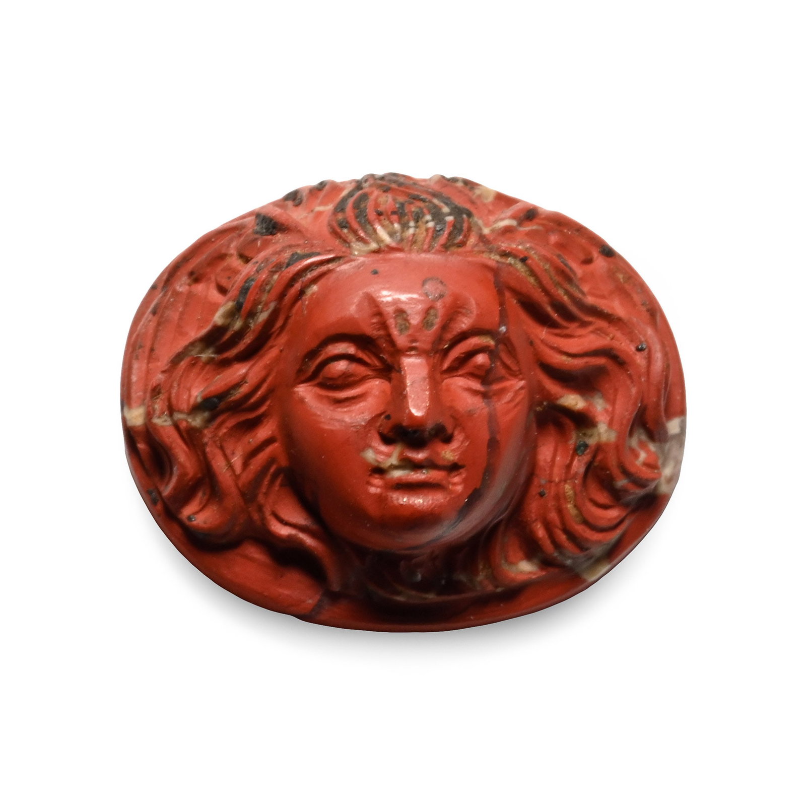 Post Classical Red Jasper Cameo of Medusa: 20th century A.D. Oval cameo with the face of Medusa with flowing hair, furrowed brow and piercing gaze. 1.48 grams, 14 mm (1/2 in.). Acquired on the European art market. TimeLine Auctions follows a r