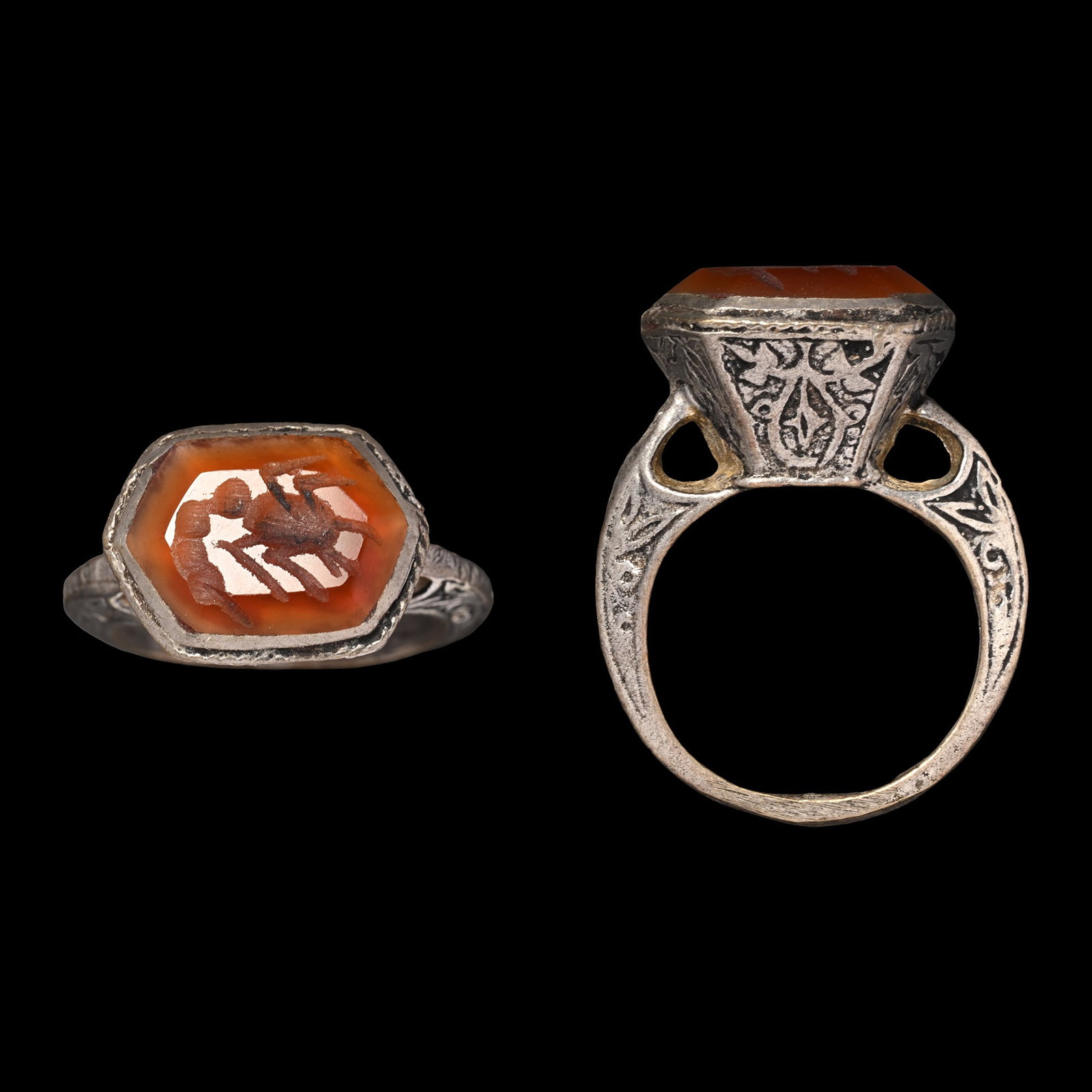 Bedouin Silver-Coloured Metal Ring with Gemstone: 20th century A.D. Expanding hoop with tendril decoration, tapering hexagonal bezel set with a carnelian intaglio with insect motif. 6.62 grams, 30.37 mm overall, 17.97 x 16.69 mm internal diameter (ap