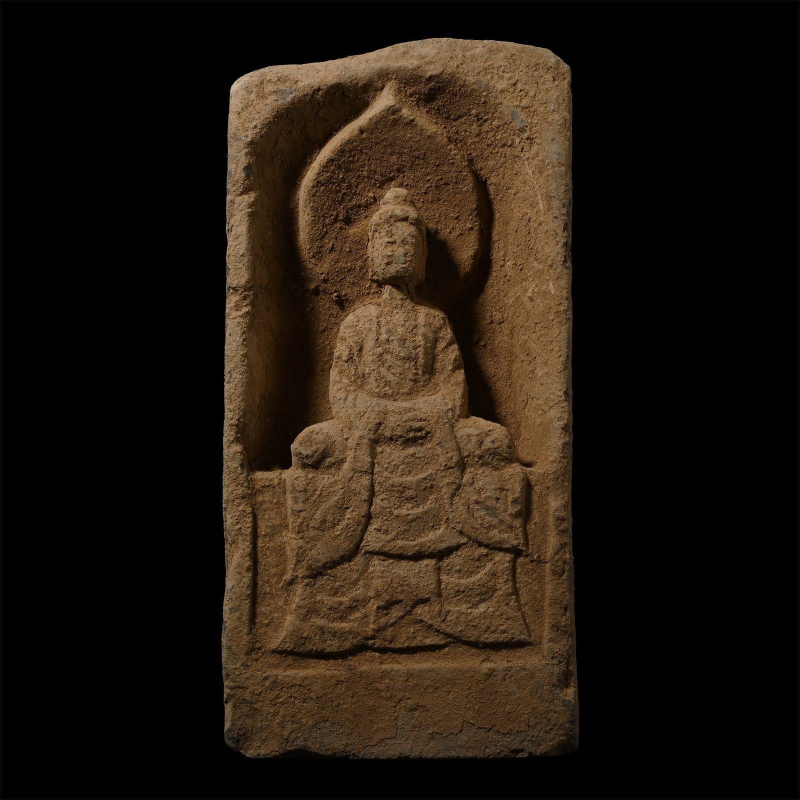 Chinese Northern Wei Terracotta Buddha Brick: Northern Wei, 386-534 A.D. or later. Buddha depicted seated in a niche with an aureole behind him, his hands crossed and held at his lap. 4.05 kg, 32 x 15 cm (12 5/8 x 6in.). Ex Hong Kong gentleman's 