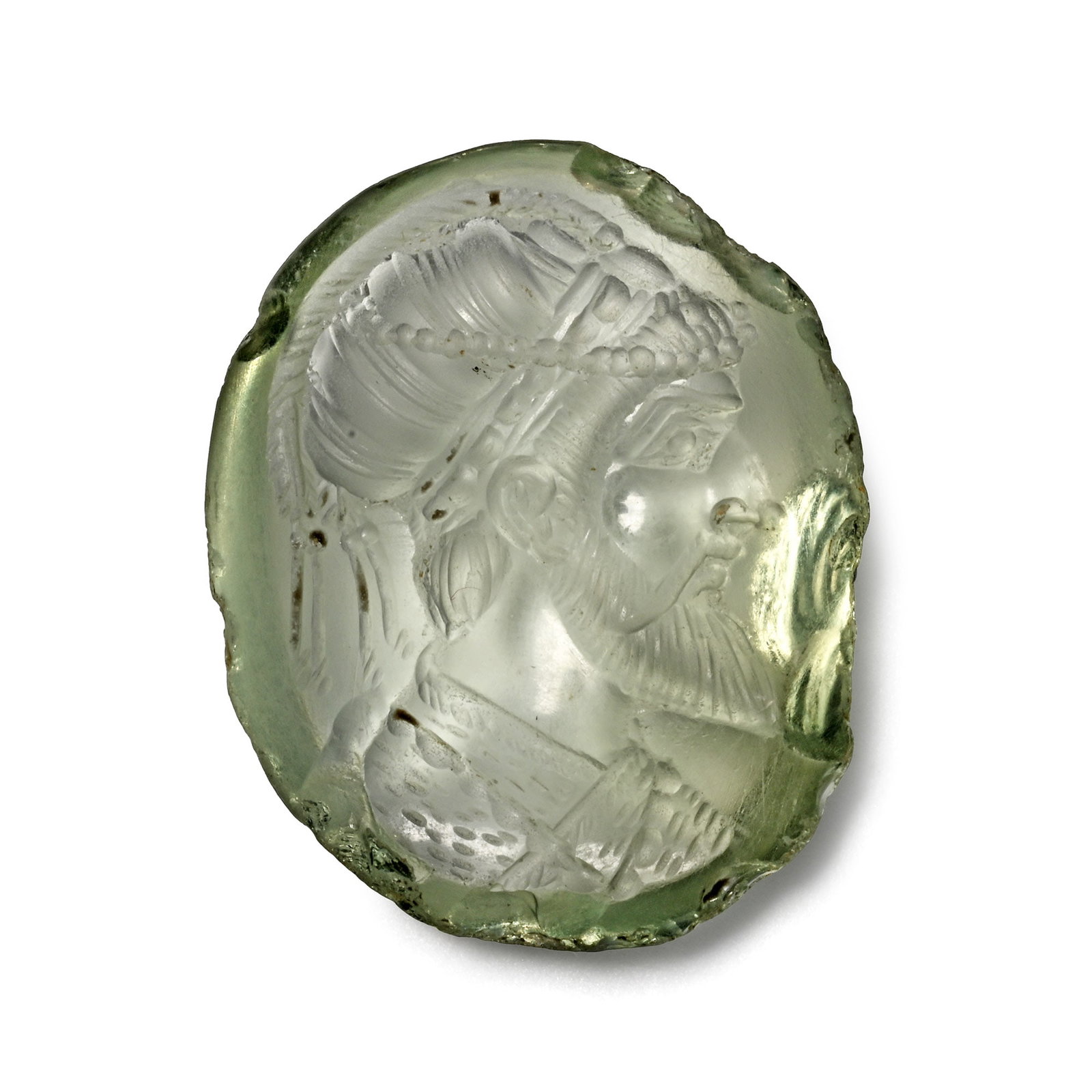 Early Mughal Aquamarine Gemstone with Male Portrait: 16th-17th century A.D. Oval intaglio with domed base, possibly prasiolite, featuring a carved bust of an emperor facing right, wearing an elaborate headgear with a string of pearls; supplied with a mu