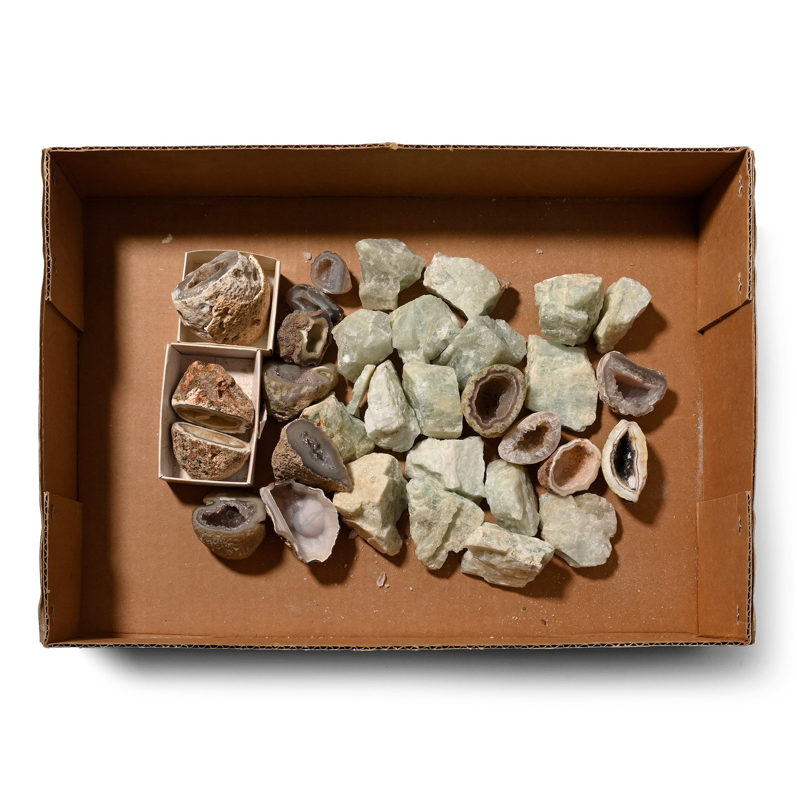 Group of Thirty-Two [32] Cut Half Agate Geode and Blue Calcite Mineral Specimens: Boxed group of cut agate geodes, most with crystal-lined cavities, and pale-blue calcite specimens. 1.85 kg total, 29-52 mm (1 1/8 - 2 in.). [32, No Reserve] Ex Mineral Imports, London, UK. Gregory, B