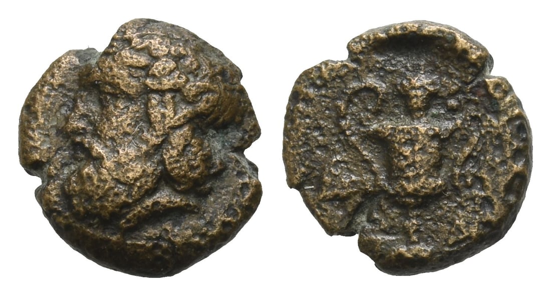 Cyclades, Naxos AE 10mm.: 4th century BC. Bearded head of Dionysos to left, wearing wreath of ivy with berries at the tip / Kantharos; grape bunch above, ivy leaves at sides, N-A flanking base. Nicolet-Pierre, Naxos II, Cantha