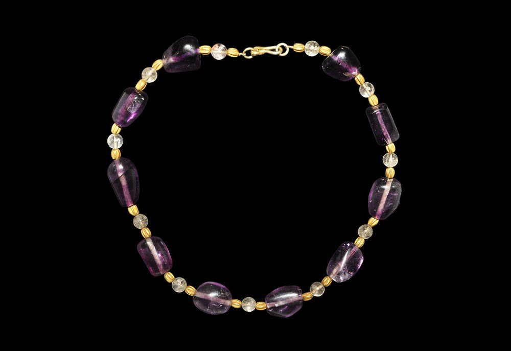 Middle Eastern Gold, Amethyst and Rock Crystal Necklace: 12th century AD and later. A designer-restrung antique Bactrian style necklace formed from irregular polished amethyst and clear quartz spherical beads with modern gold beads and hook clasp. 108 grams
