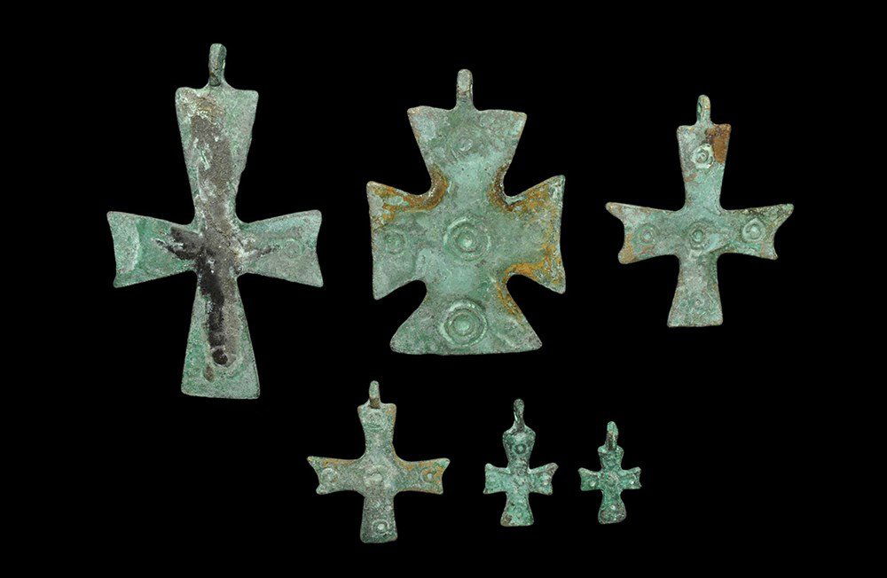 Byzantine Style Bronze Cross Pendant Group: 8th-9th century AD. A mixed group of cast bronze cruciform pendants each with expanding arms, ring-and-dot ornament to one face. 62 grams total, 24-74 mm (1 - 3"). From a Hampshire collection. [6, No