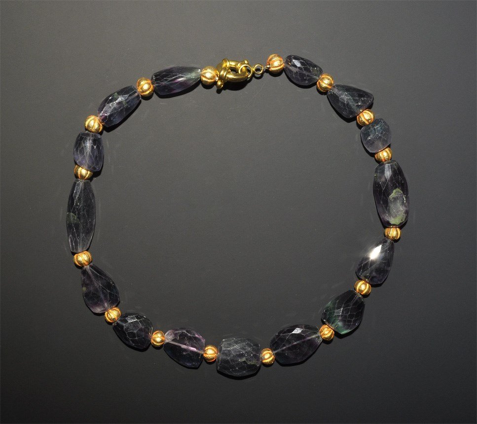 Middle Eastern Style Gilded and Facetted Fluorite Bead: A designer necklace of irregular facetted fluorite beads, with gilt metal melon beads between, modern clasp. 187 grams, 32 cm (12 1/2"). Acquired on the London art market in the early 1990s.