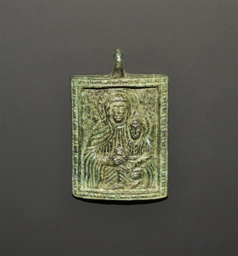 Byzantine Style Pendant Plaque: An undated archaistic rectangular plaque, convex in section, with motif of Madonna and child within a billetted frame, loop above. 38 grams, 53 mm (2"). Ex Buckinghamshire collection, UK; acquired in 