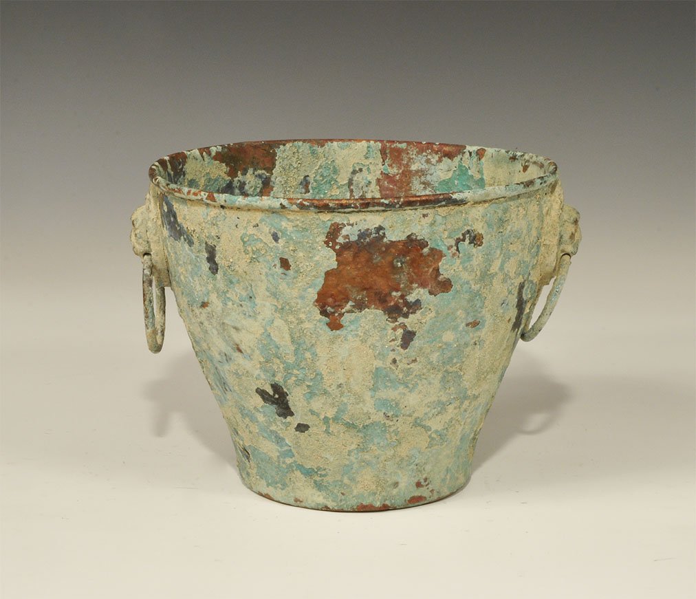 Roman Style Brass Two-Handled Situla: An undated archaistic bronze bell-shaped situla with two lion-head escutcheons each with a loop in its mouth. 625 grams, 20 cm (8"). Acquired on the London art market before 1995. [No Reserve]