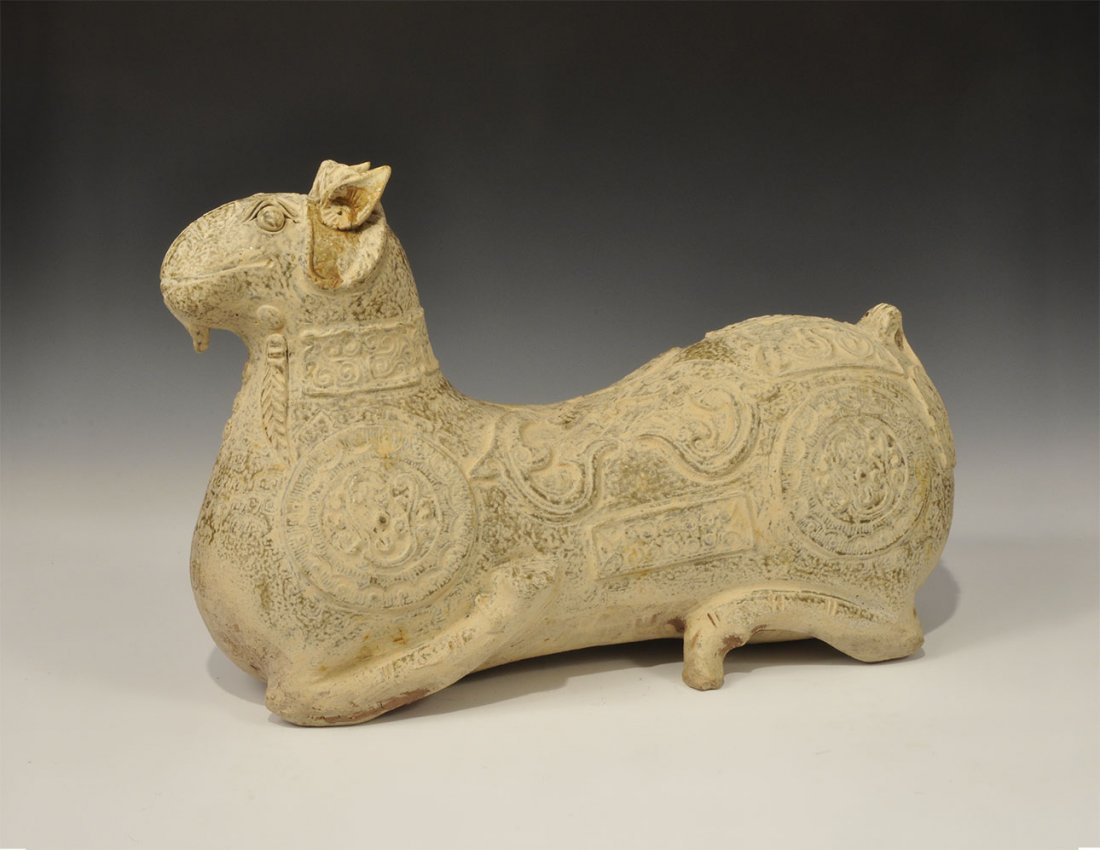Cambodian Style Large Ceramic Animal with Decorative: An undated archaistic hollow greyware animal statuette with front legs returned to the flanks, the surface with scrolled foliage detailing. 8.4 kg, 49 cm (19 1/4"). Property of a London collector, acq