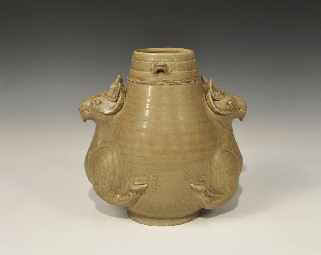 Cambodian Style Ceramic Vessel with Ram's Heads: An undated archaistic conical vessel with circumferential bands and small loops to the rim, addorsed foreparts of two rams to the body each with pierced forehead. 2.8 kg, 24.5 cm (9 1/2"). Property of