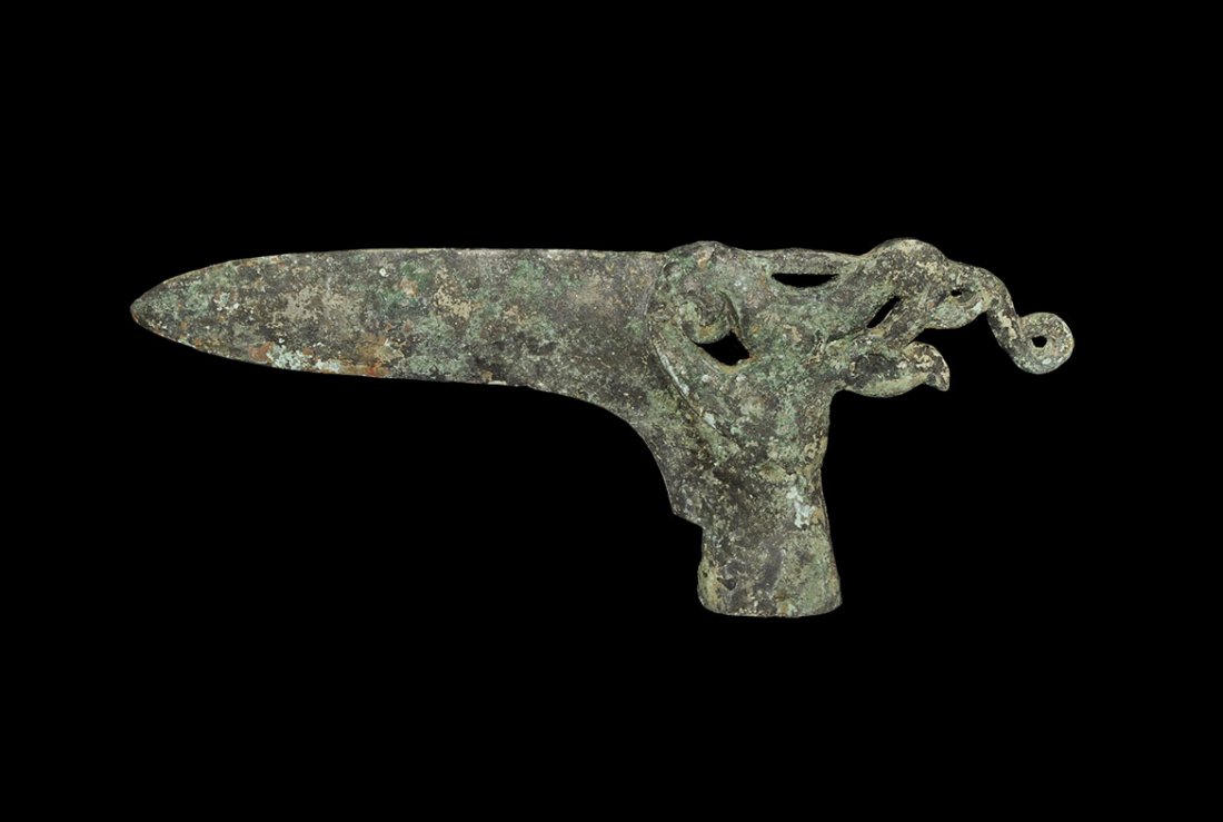 Chinese Style Bronze Halberd with Lion: An undated archaistic cast bronze halberd with elliptical socket, L-shaped blade with openwork animal to the rear. 482 grams, 22.7 cm (9"). UK art market, acquired prior to 1998.