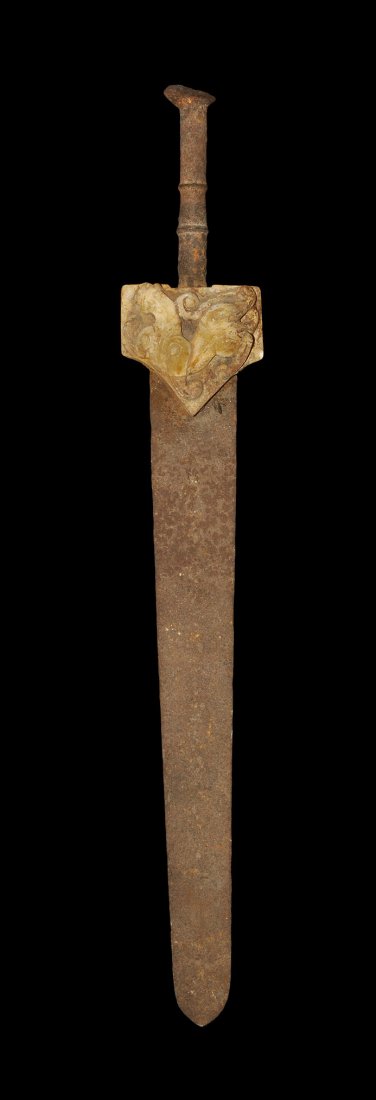 Chinese Style Iron Sword with Stone Lower Guard: An undated archaistic iron short sword in Han Dynasty style, with tongue-shaped blade; pentagonal carved stone guard with zoomorph to the obverse, scrolled design to the reverse, two transverse discoi